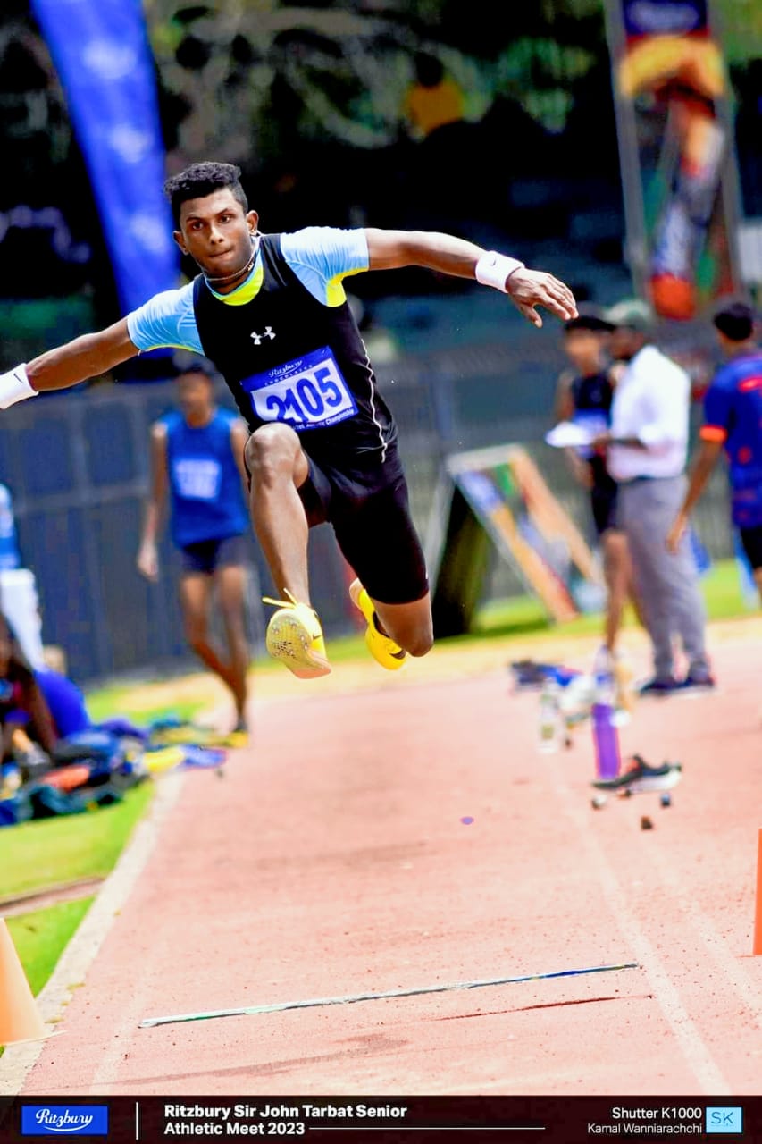 Athlete mid-air in long jump at 2023 Sir John Tarbat Senior Athletic Meet.