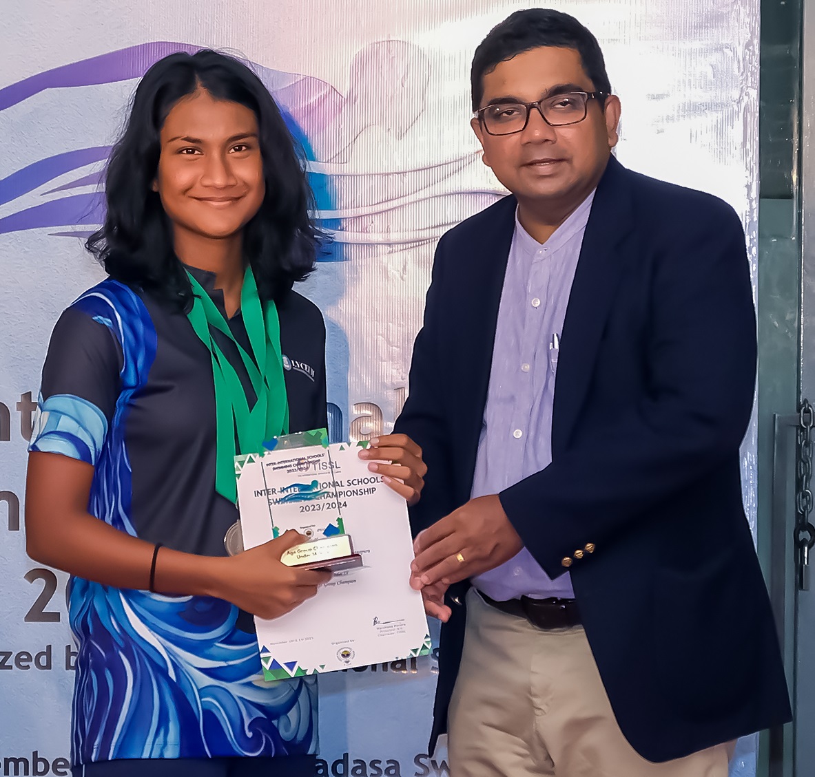 Young athlete receiving award from official at water sports event.