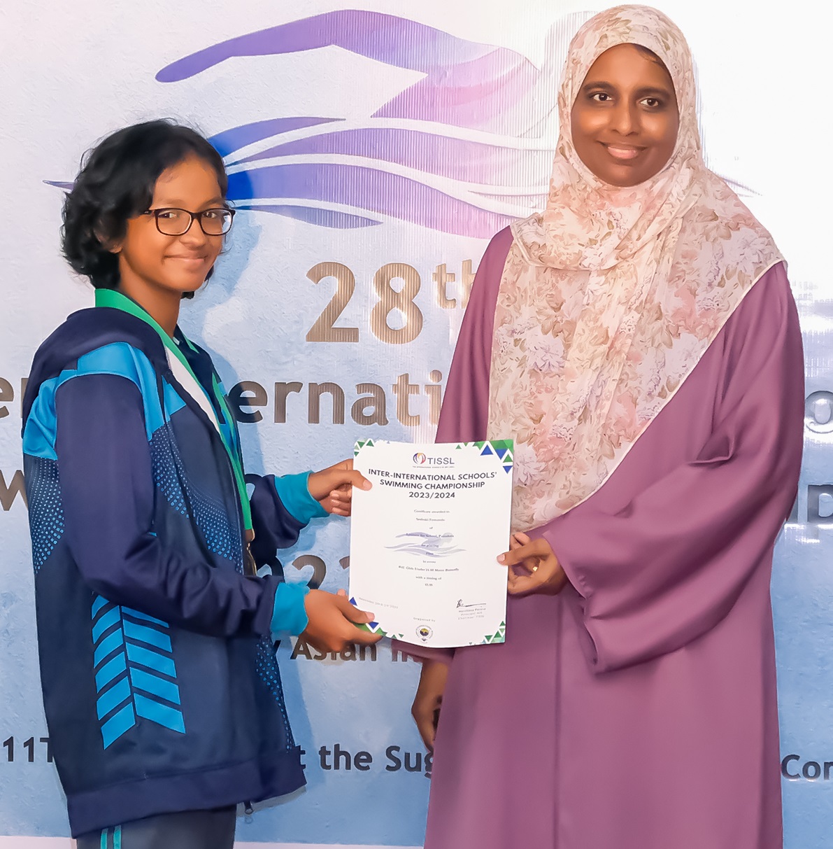 Young woman receiving an award at the 28th International event.