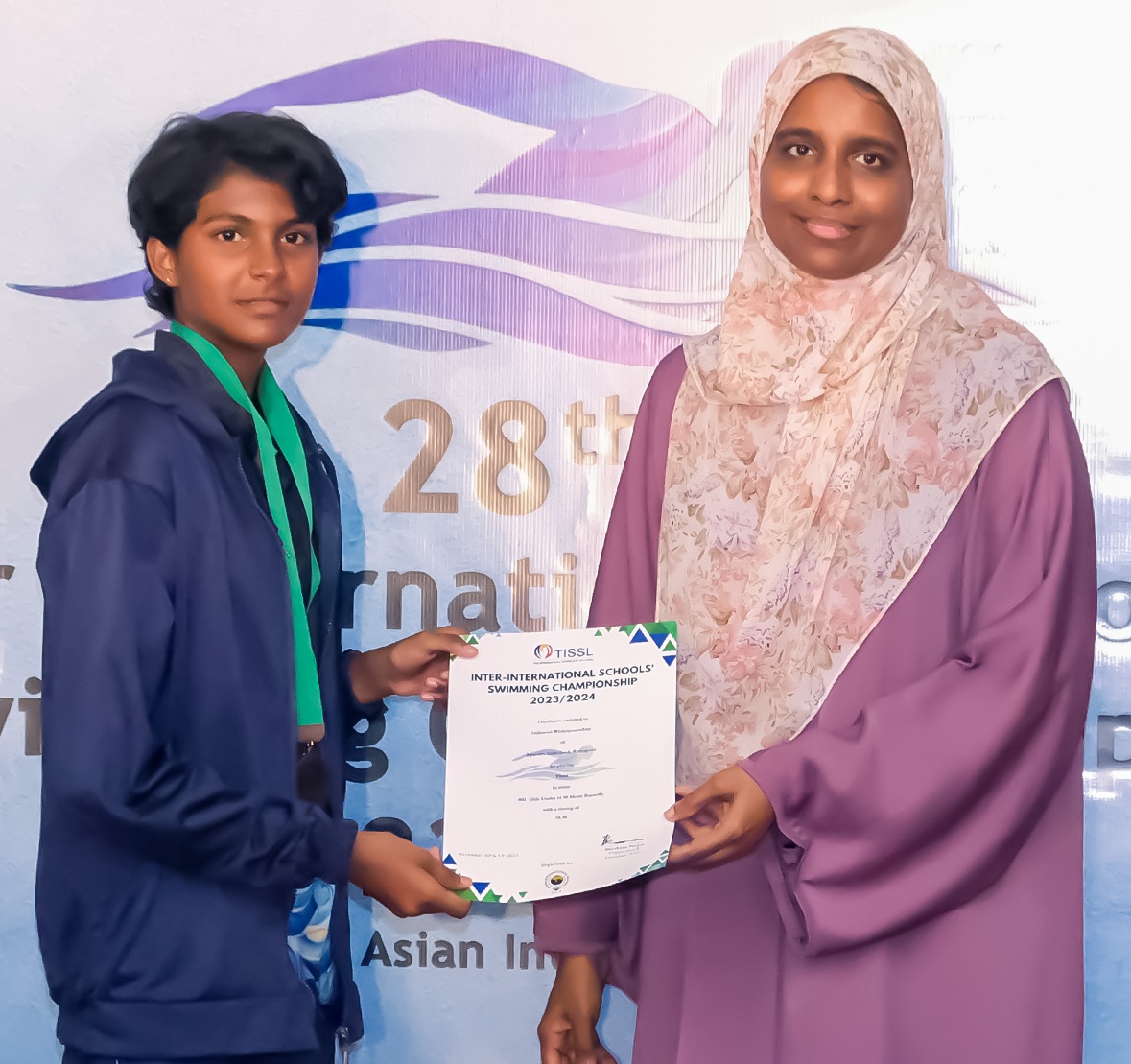 Young participant receives award certificate at 28th International Asian Event ceremony