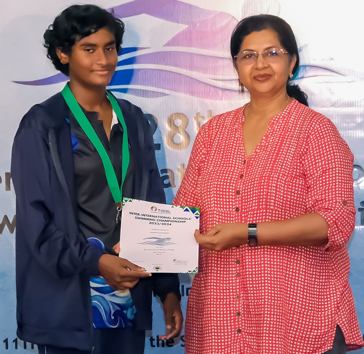 Young achiever receiving award from proud mentor at ceremony.