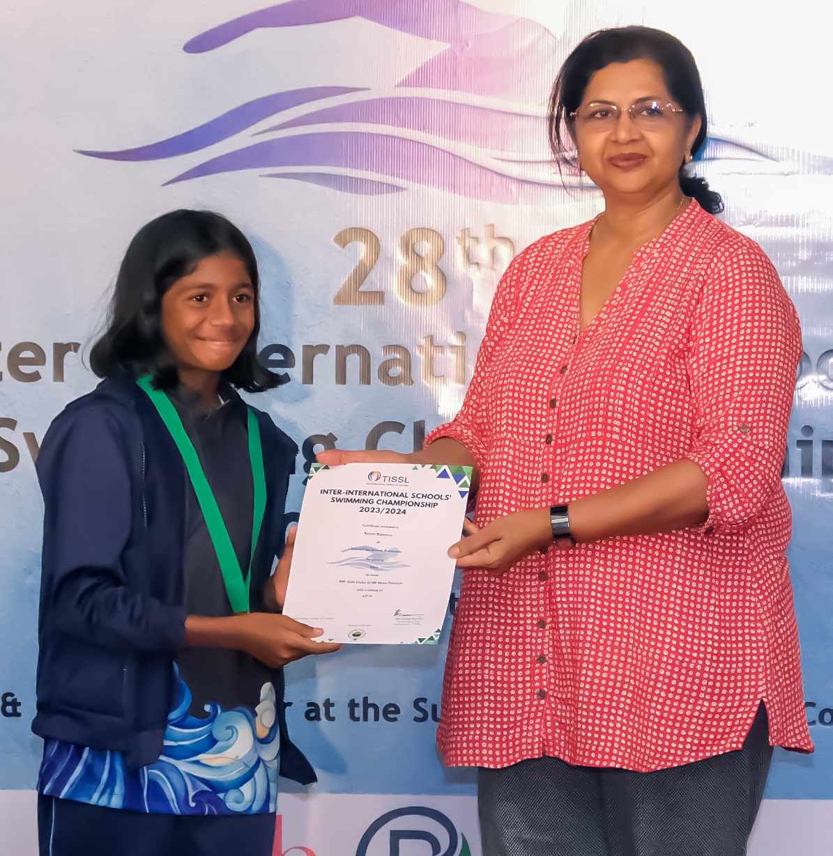 Young swimmer receives certificate at 28th International Swimming Competition.