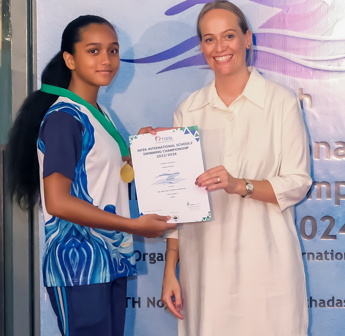 Young girl receives award from smiling woman at 2022 ceremony.