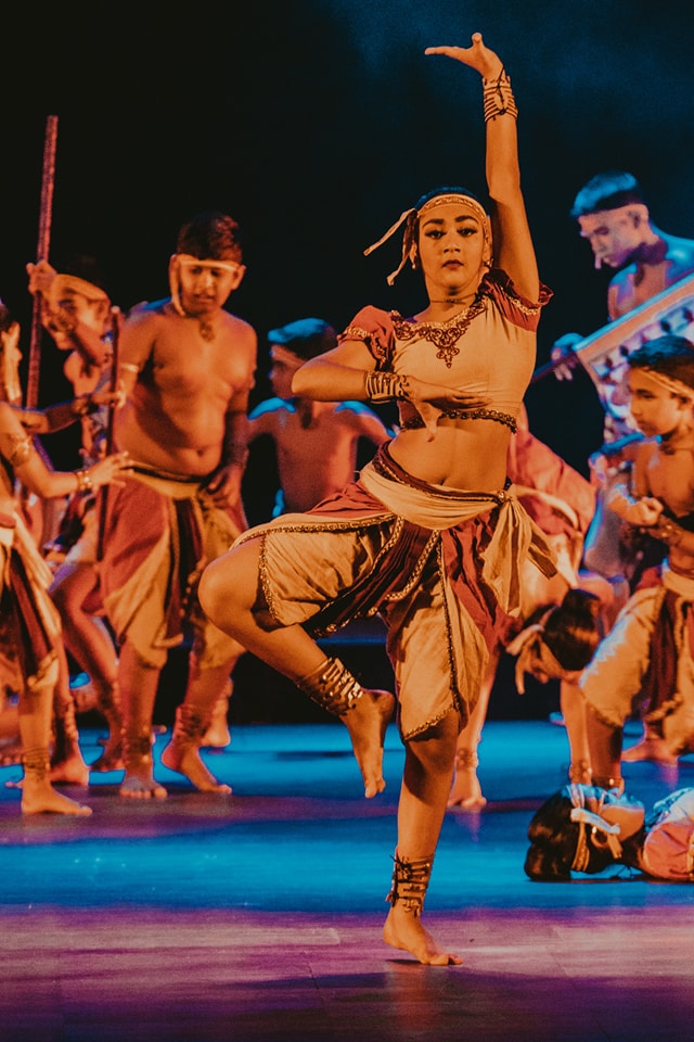 Traditional dance performance with vibrant attire and dramatic lighting.