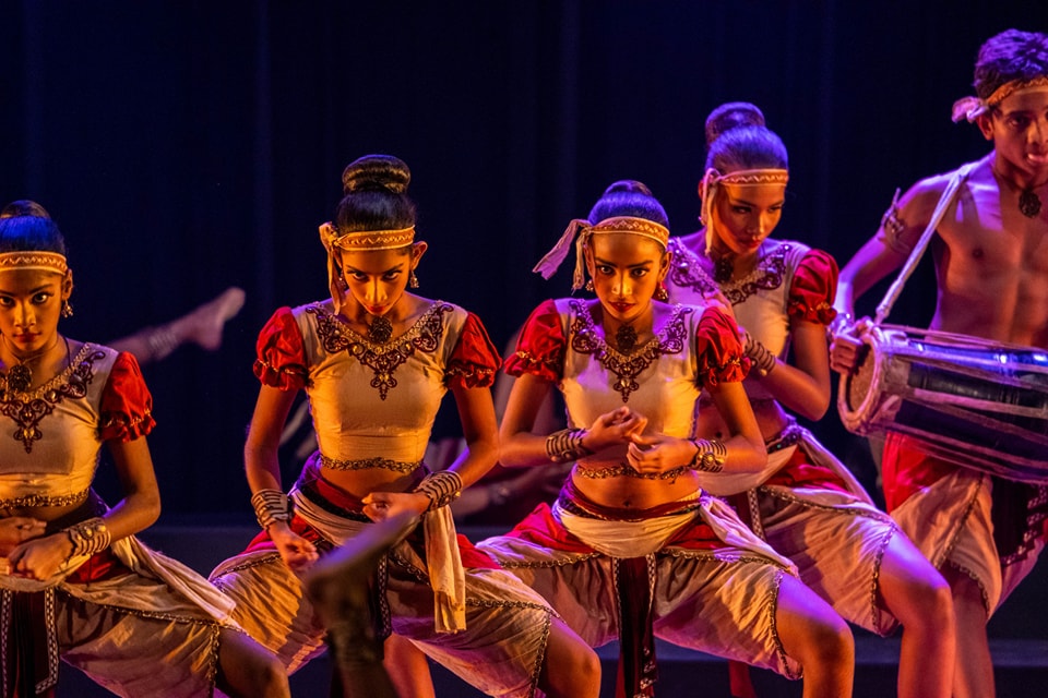 Traditional dancers in vibrant costumes with live drumming.