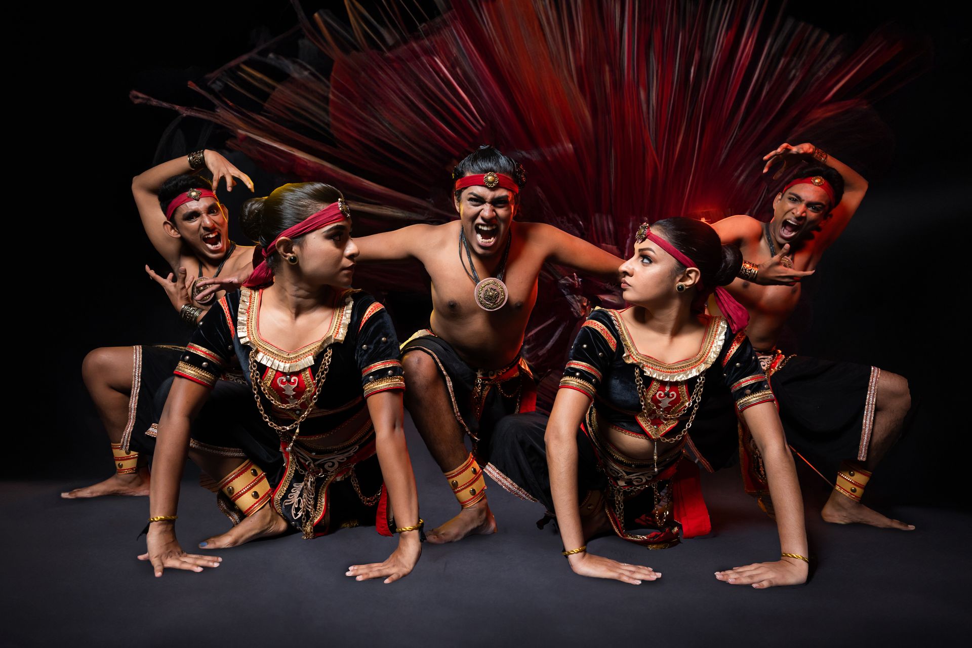 Fierce dancers in traditional costumes perform a powerful ritual with dramatic red lighting.