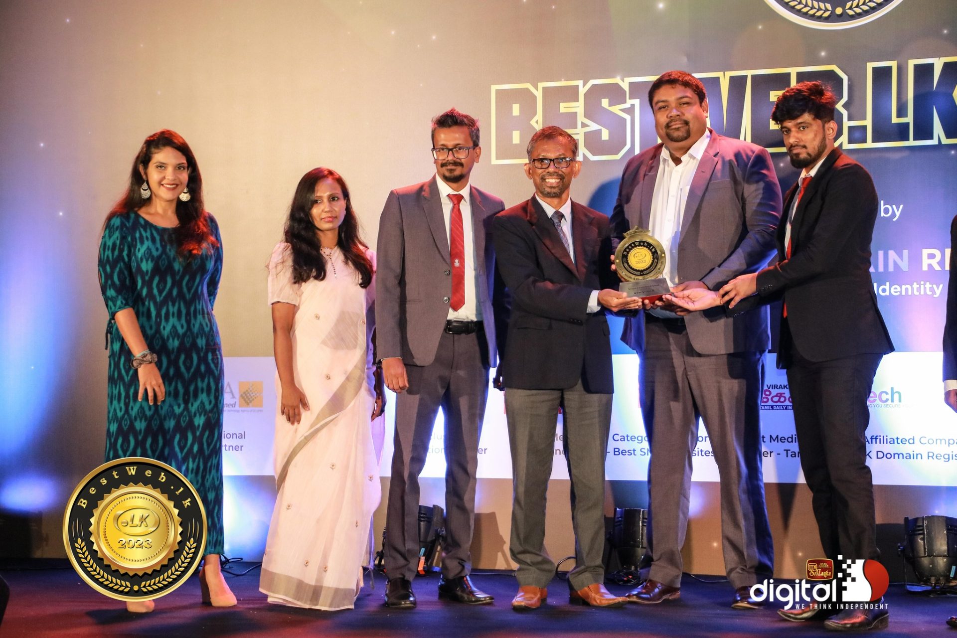 Six people on stage at BestWeb.LK Awards, celebrating a digital achievement.