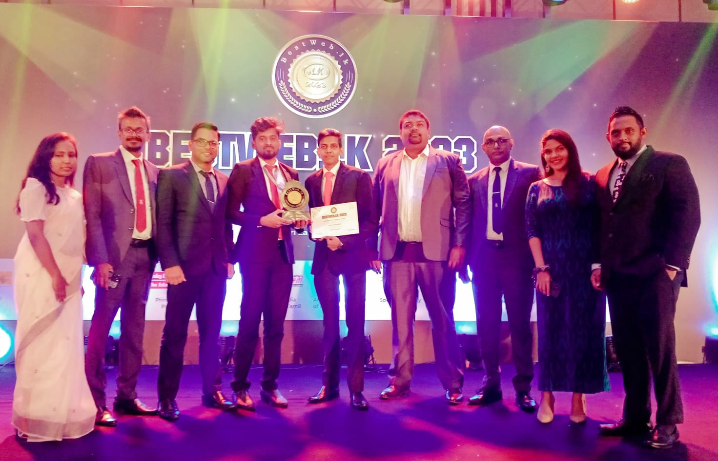 Group of nine at Best of the Best 2023 awards ceremony holding an award and certificate.