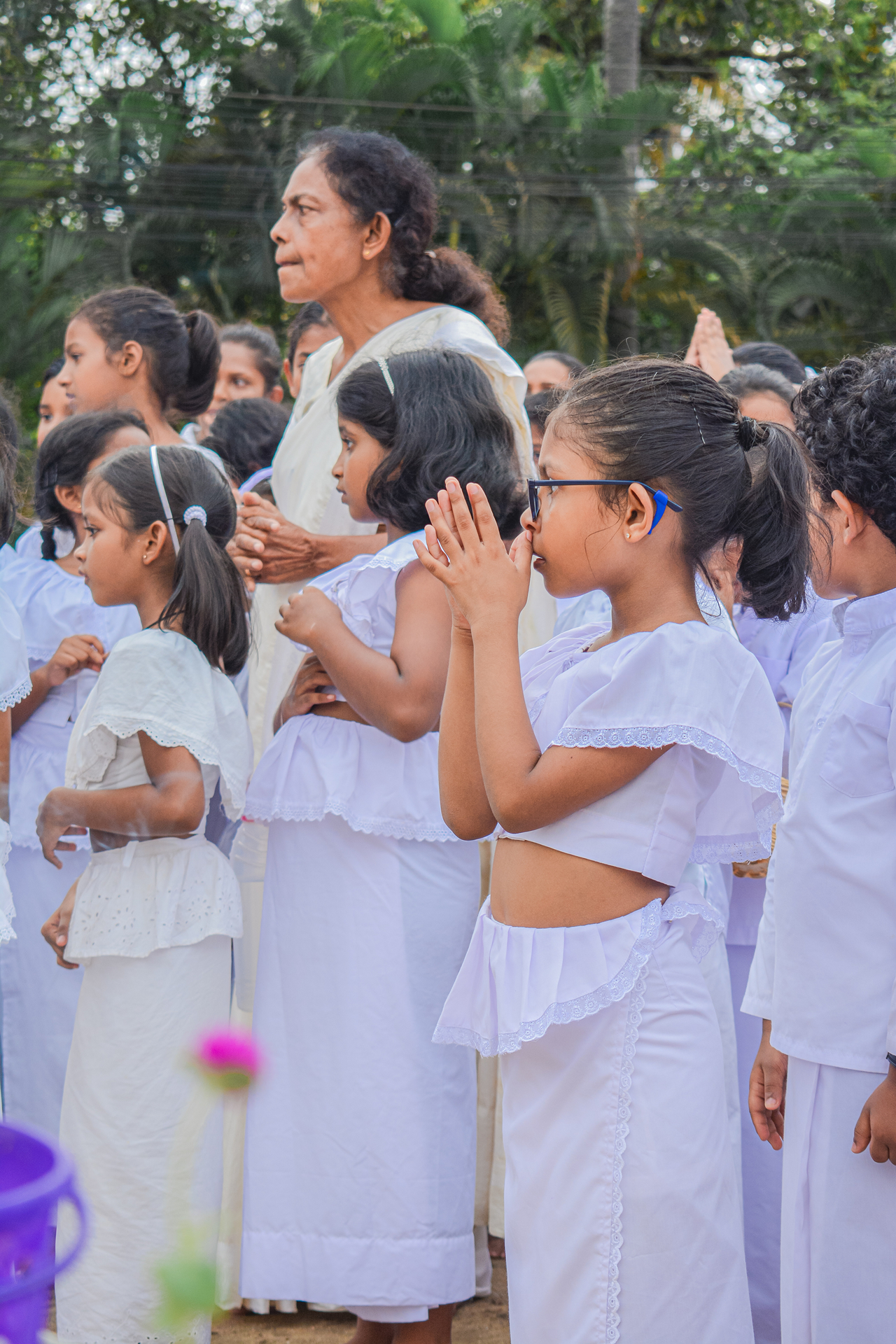 Children in white participate in an outdoor spiritual ceremony.