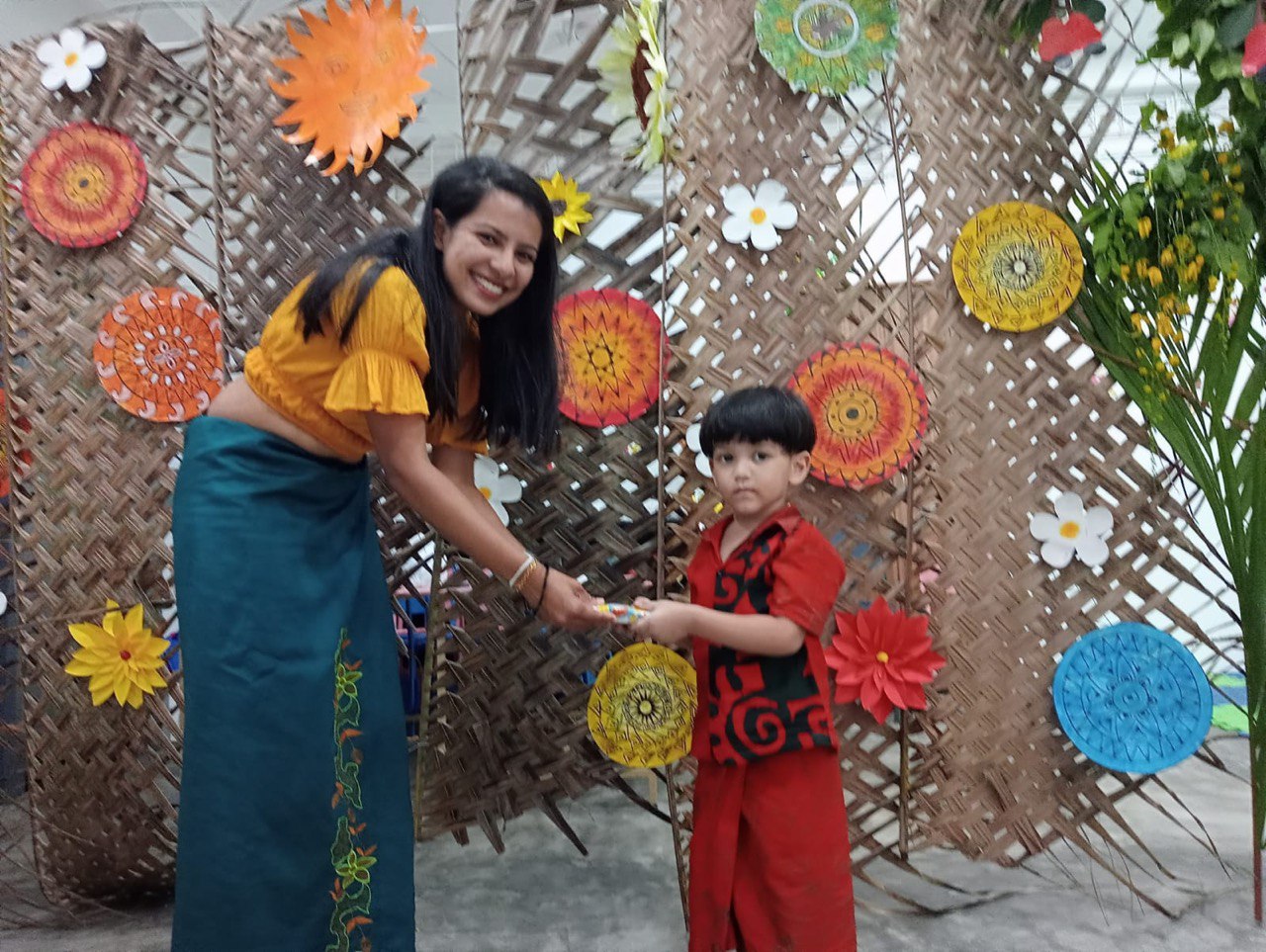 Woman and child in colorful traditional attire during a festive cultural celebration.