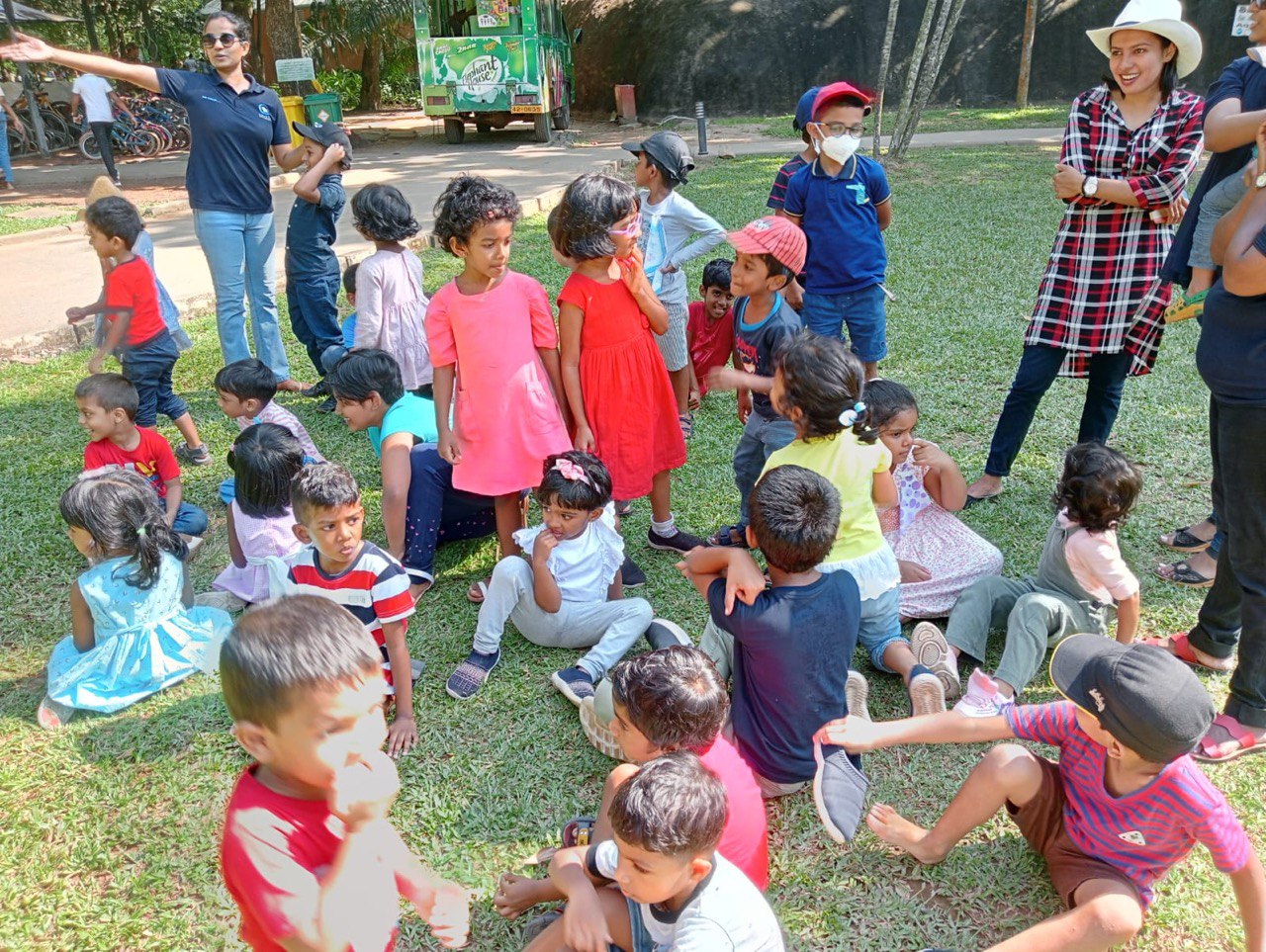 Children playing in a sunny park with adult supervision.