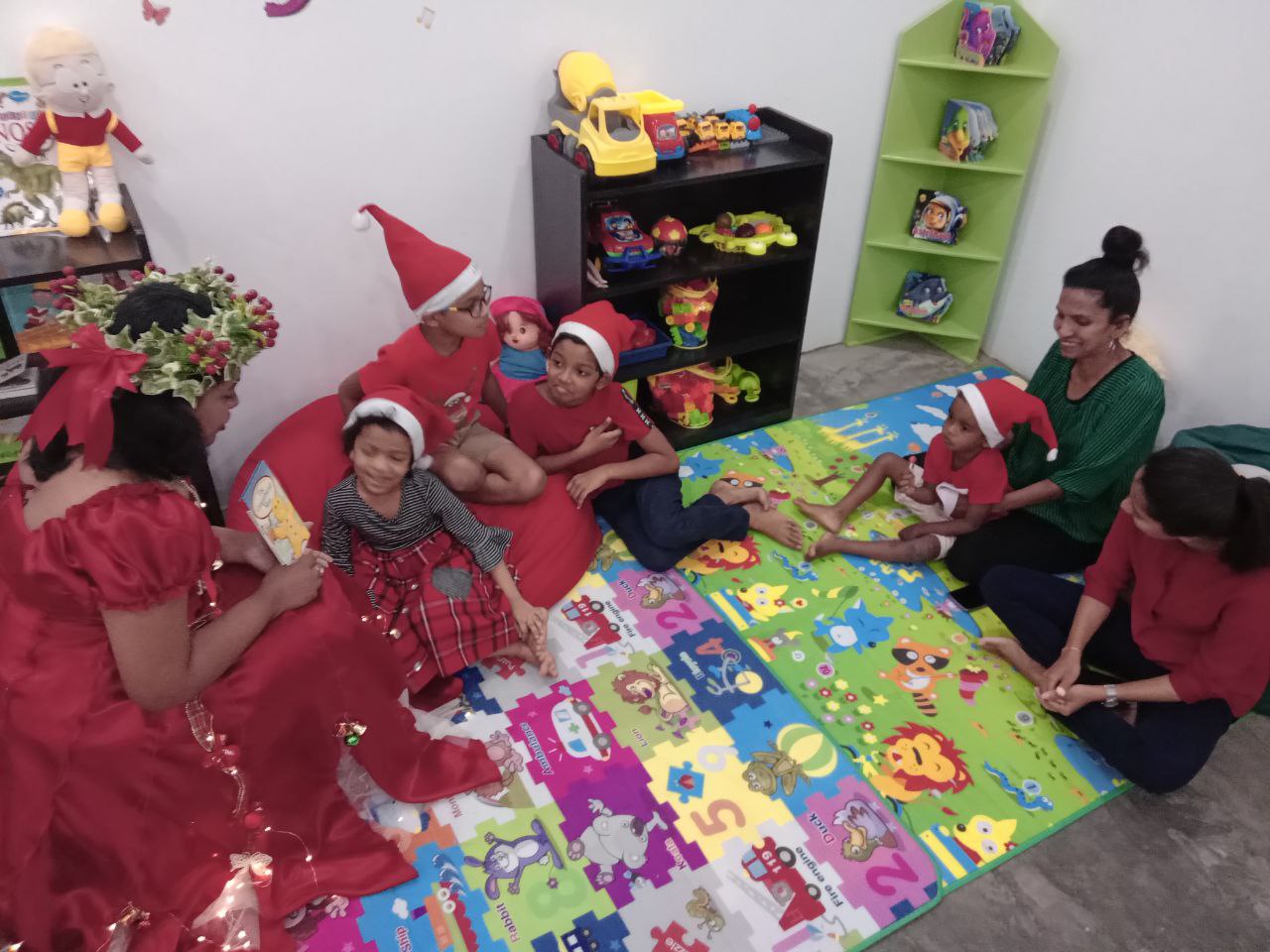 Holiday celebration in a colorful playroom with adults and children.