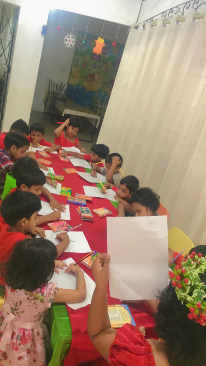 Children creating art together around a colorful table.