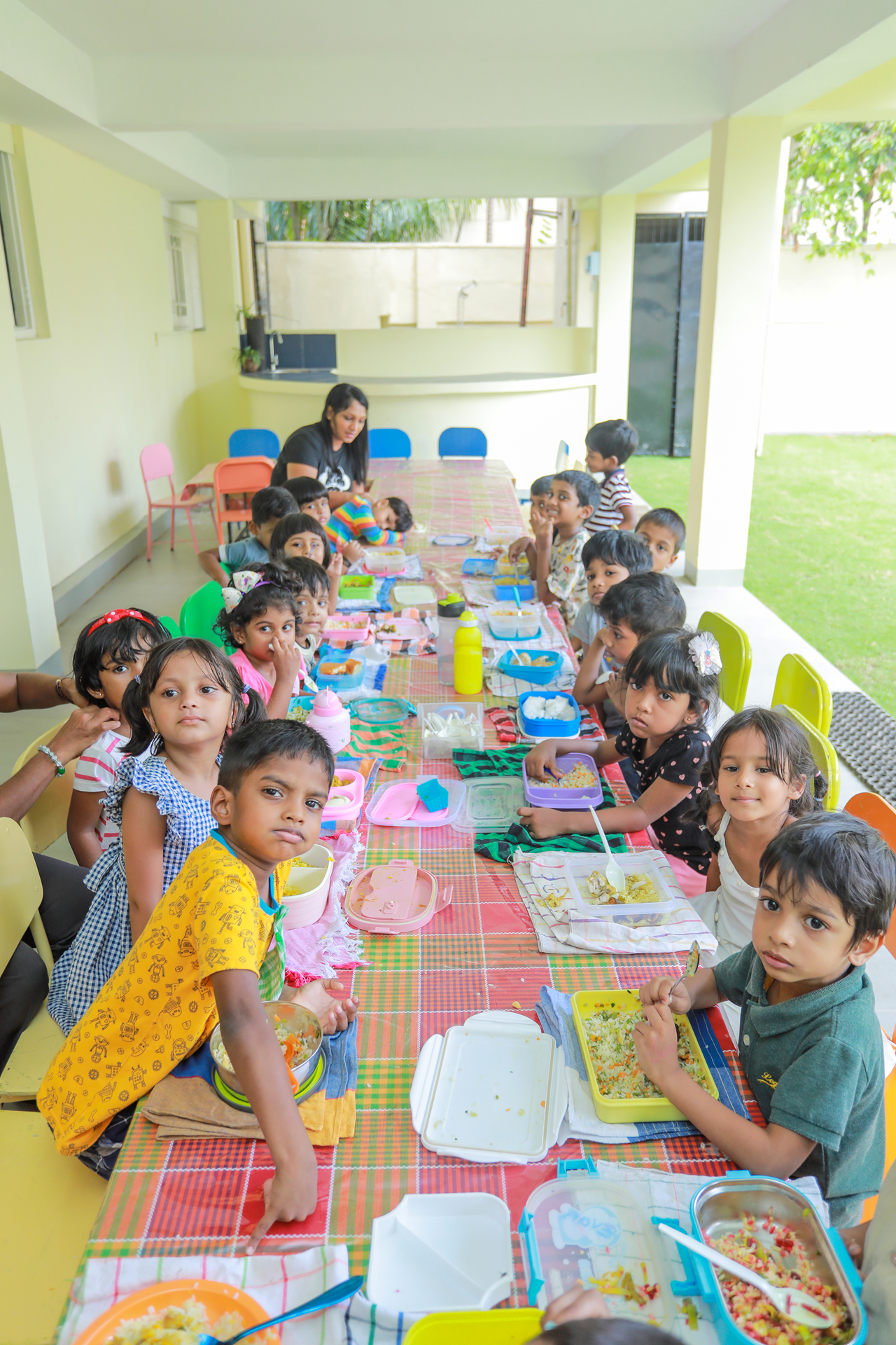 Children enjoying lunch together at a colorful school setting.