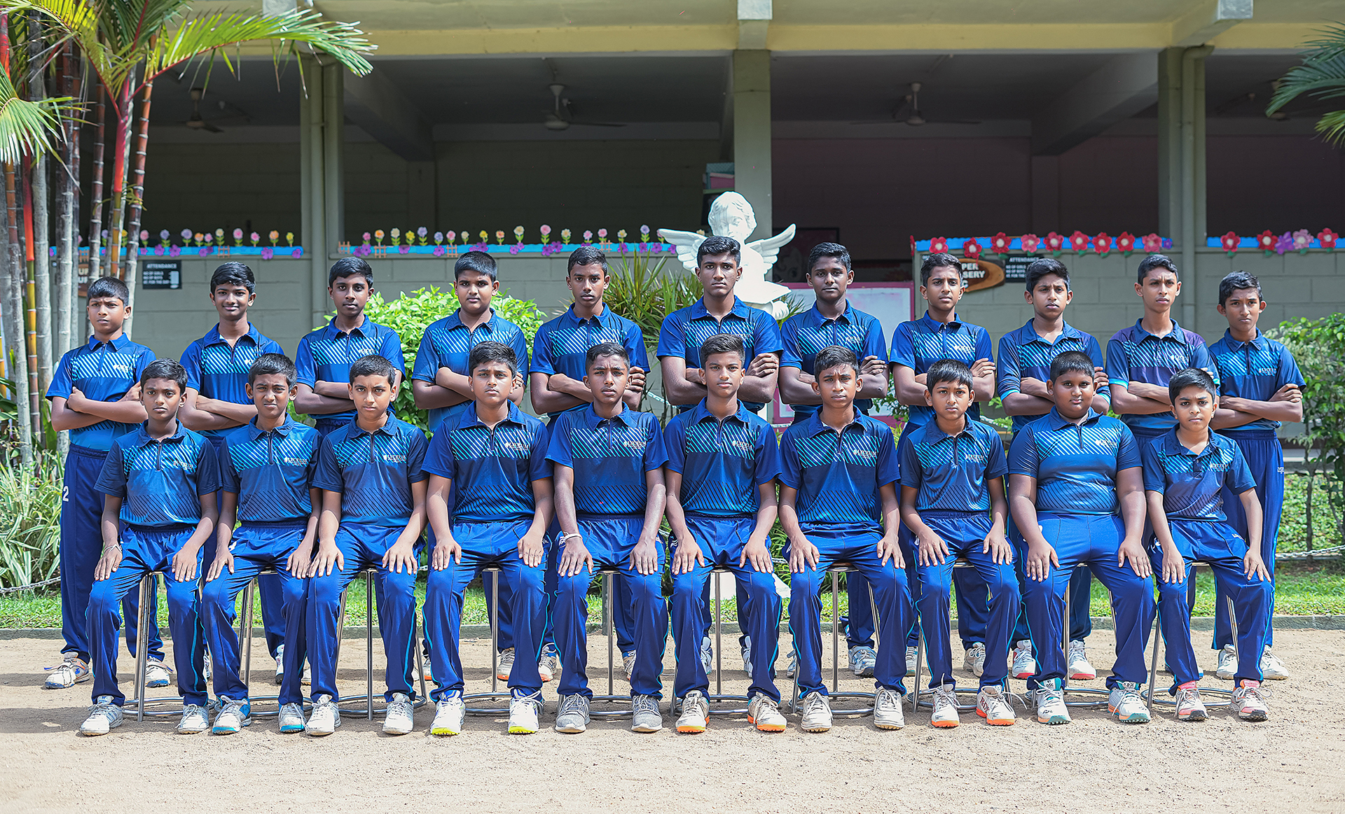 Young boys cricket team posing outdoors with a festive background.