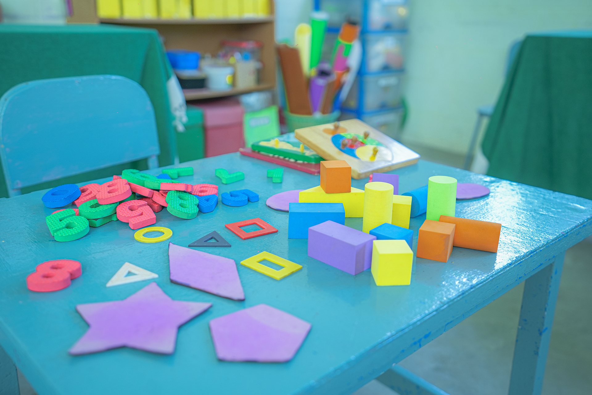 Colorful classroom table with educational toys and geometric shapes.