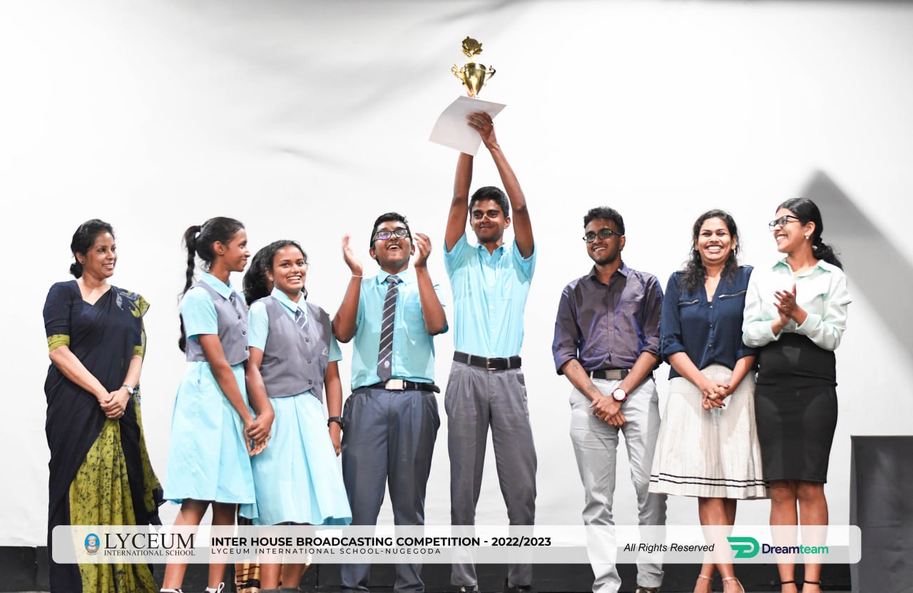 Winners of Lyceum 2022/2023 Oratorical Competition celebrate victory onstage.