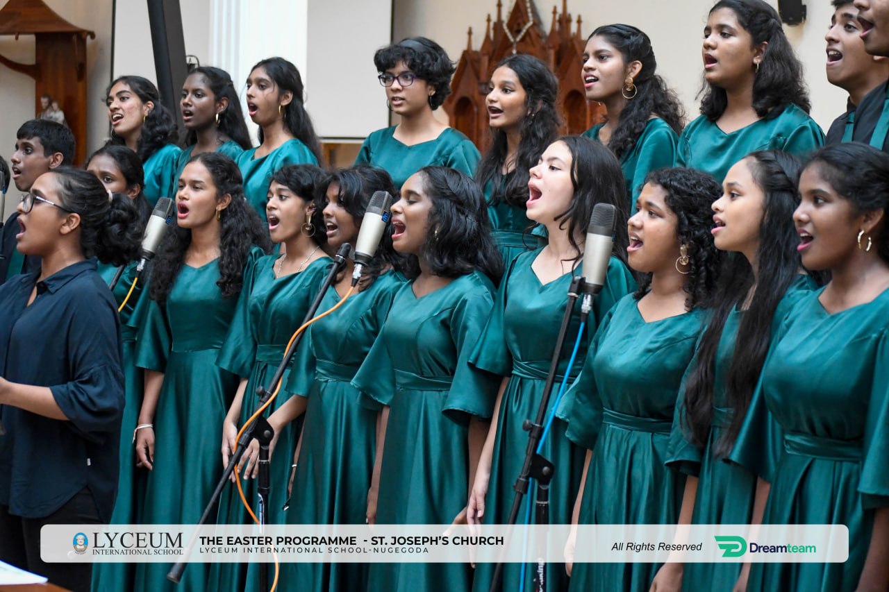 Young womens choir in teal dresses performing at St. Josephs Church.