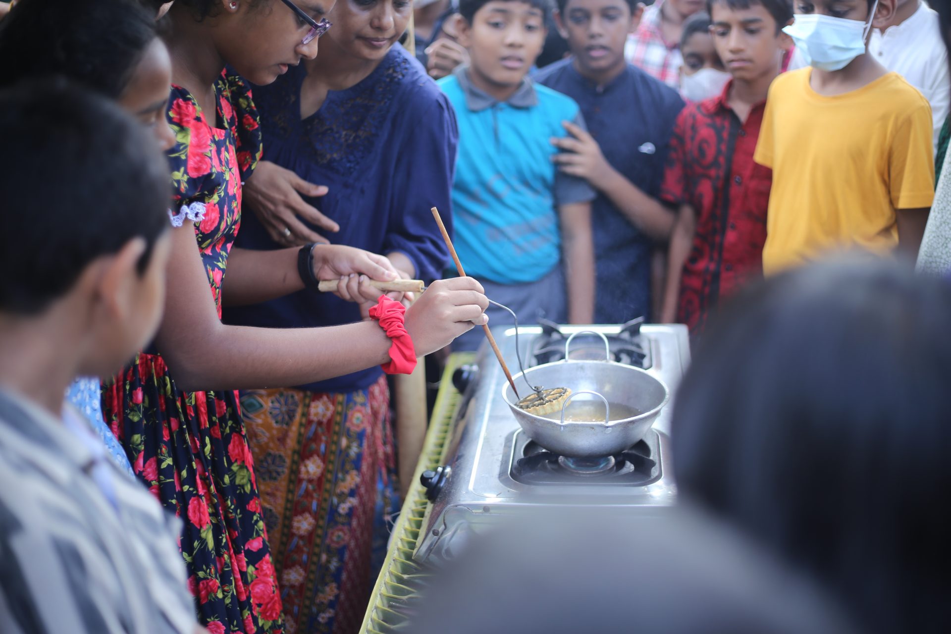 Children engaged in a lively outdoor cooking class, guided by an instructor.