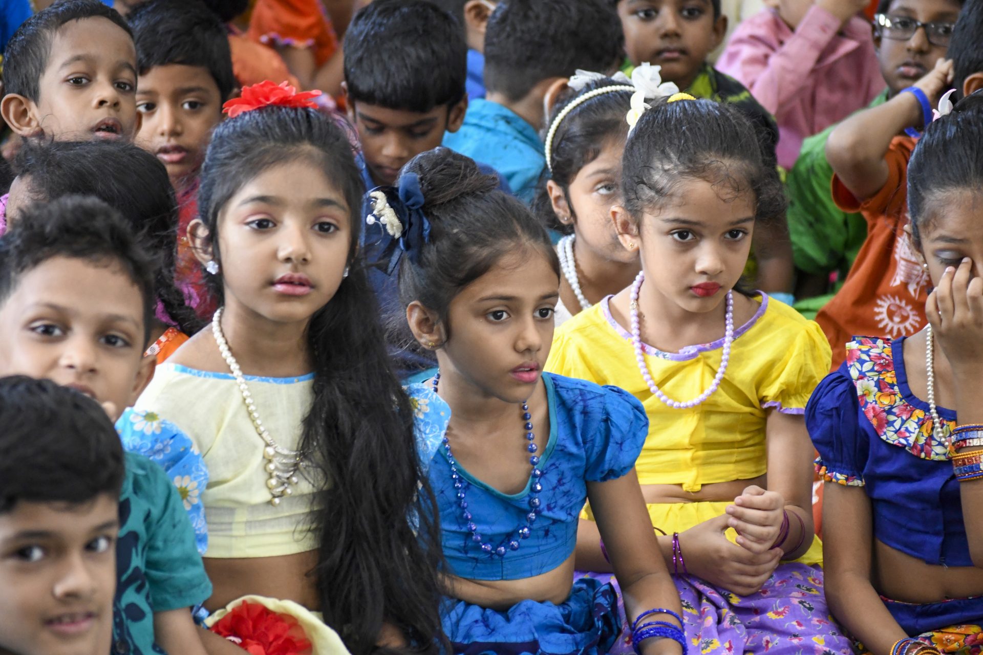 Children in colorful traditional clothing at a cultural celebration.