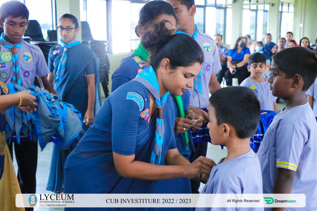 Lyceum International School Cub Investiture Ceremony 2022/2023: Staff pin badges on student uniforms.