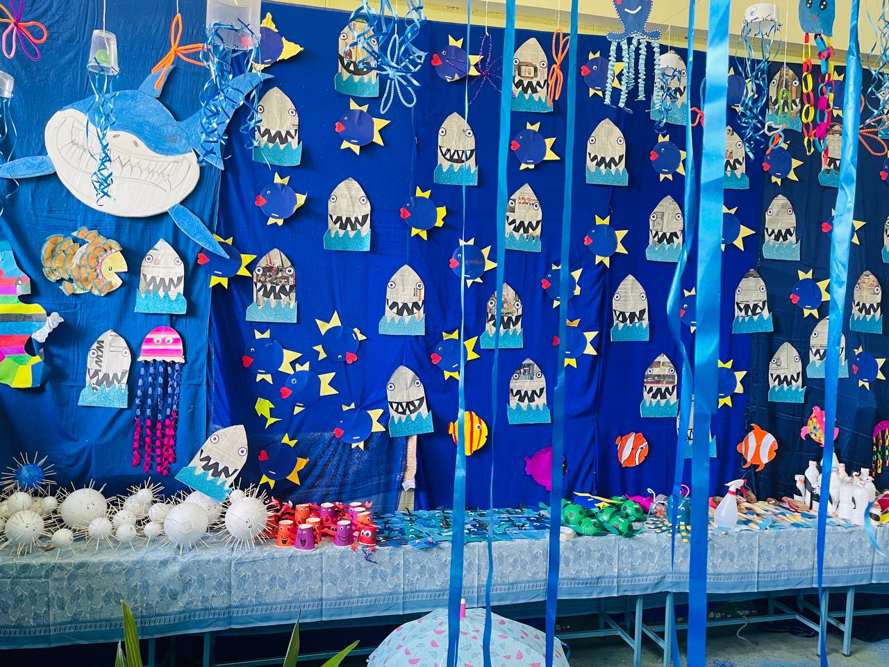 Underwater-themed classroom decor with blue backdrop and colorful sea creature crafts.