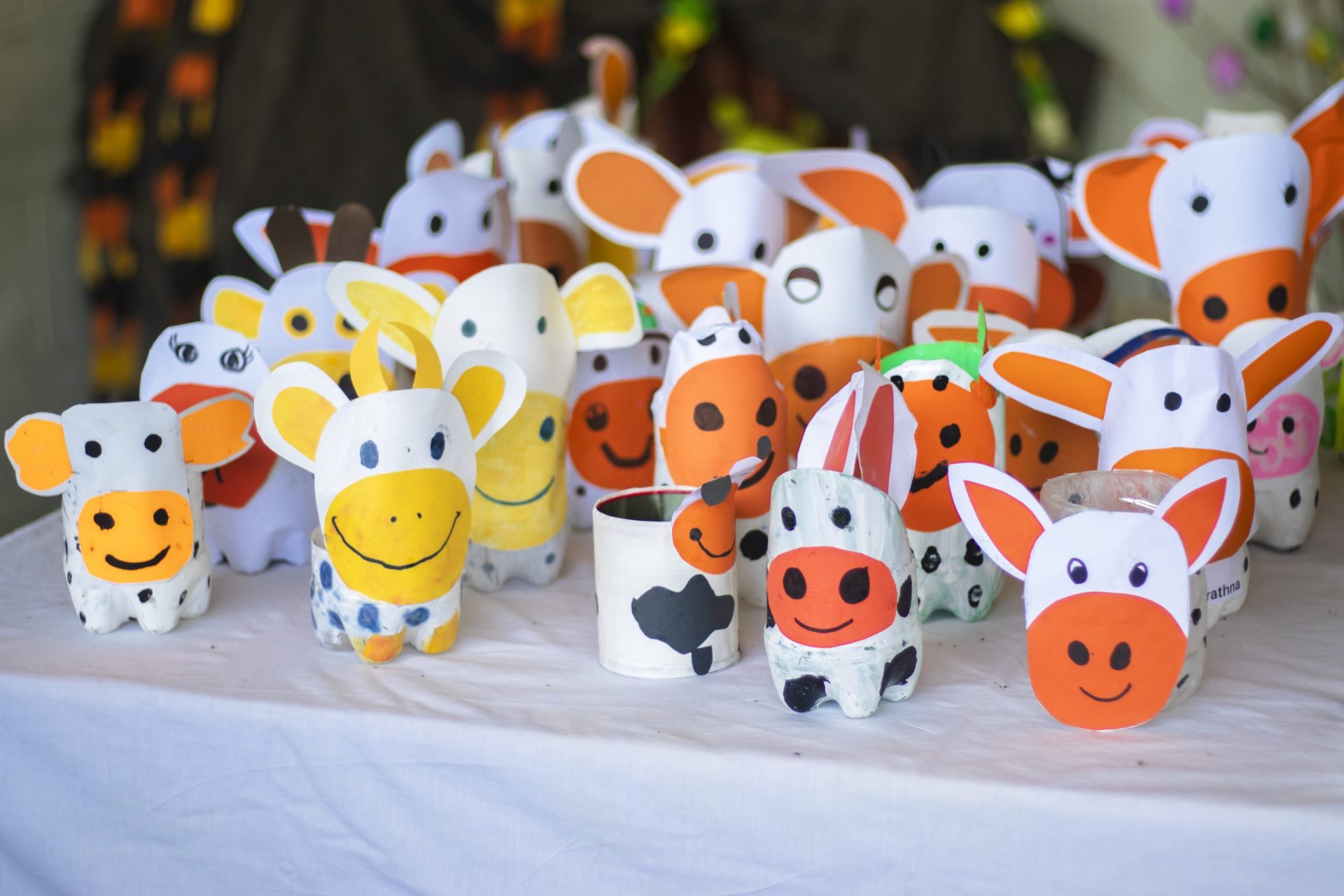 Colorful recycled cow figures made from plastic bottles on display.