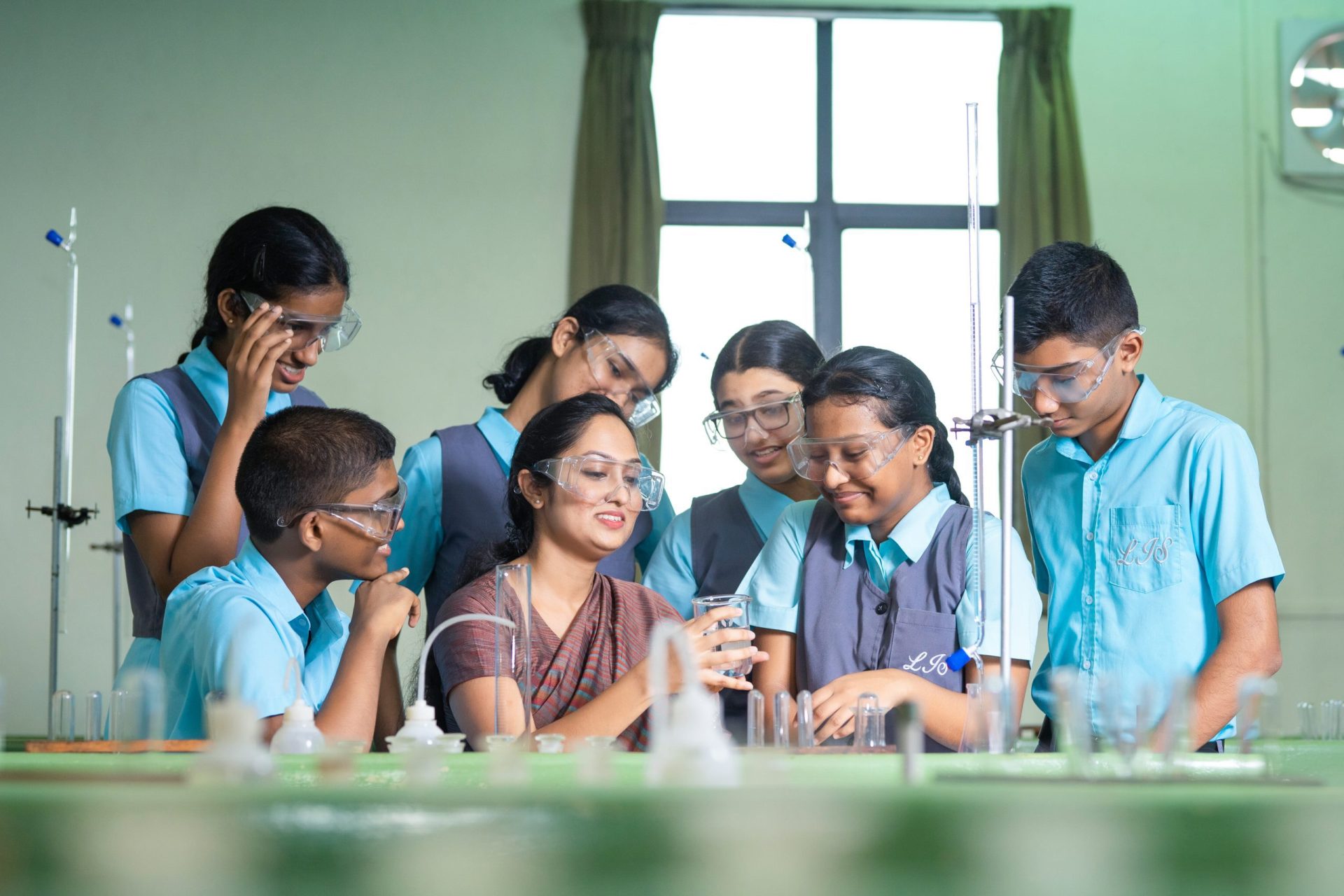 Teacher and students engaged in hands-on science experiment in a bright lab.