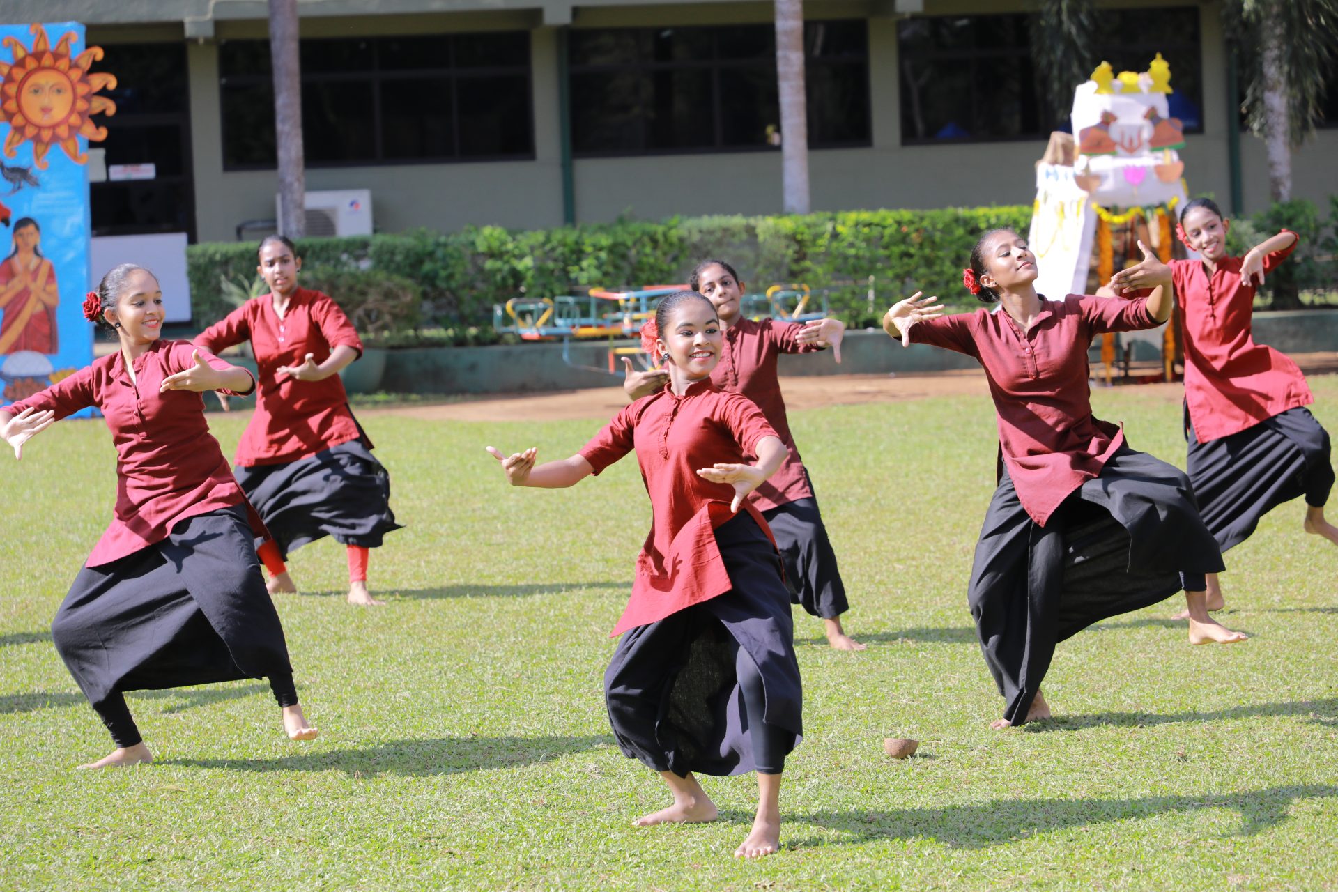 Young women perform synchronized traditional dance at outdoor cultural festival.