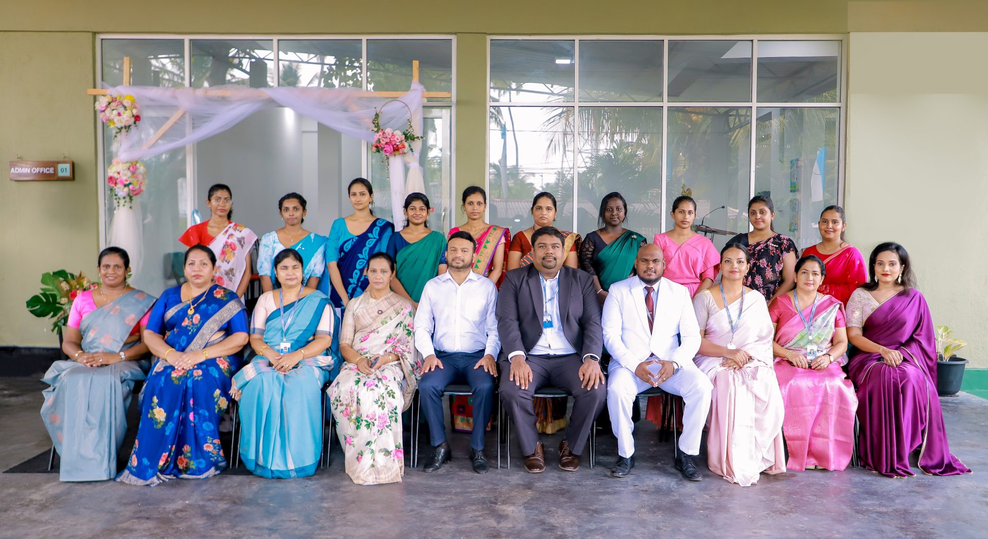 Group photo of 20 people in colorful traditional attire at a celebratory event.
