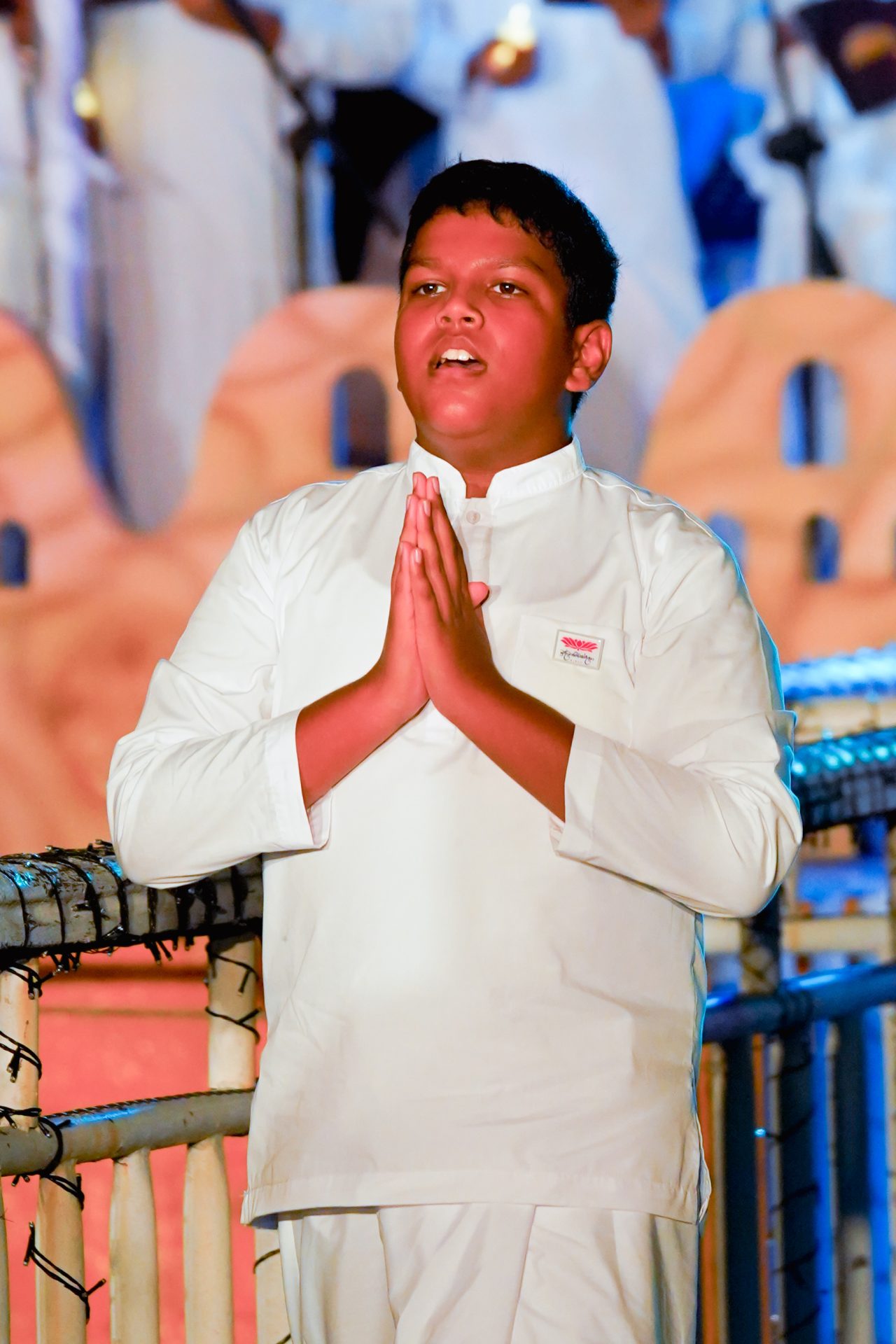 Young boy in prayer at a ceremonial event.