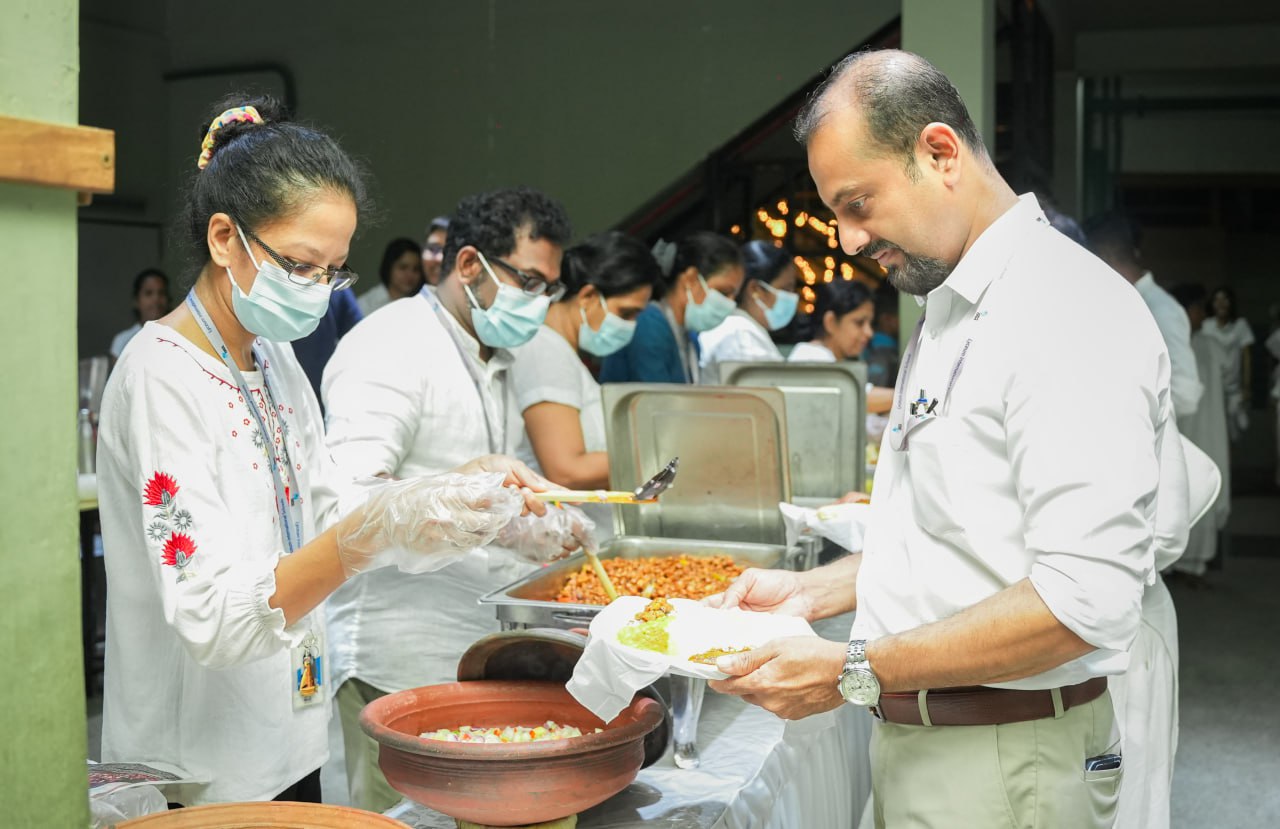 Community food distribution event with masked volunteers serving meals.