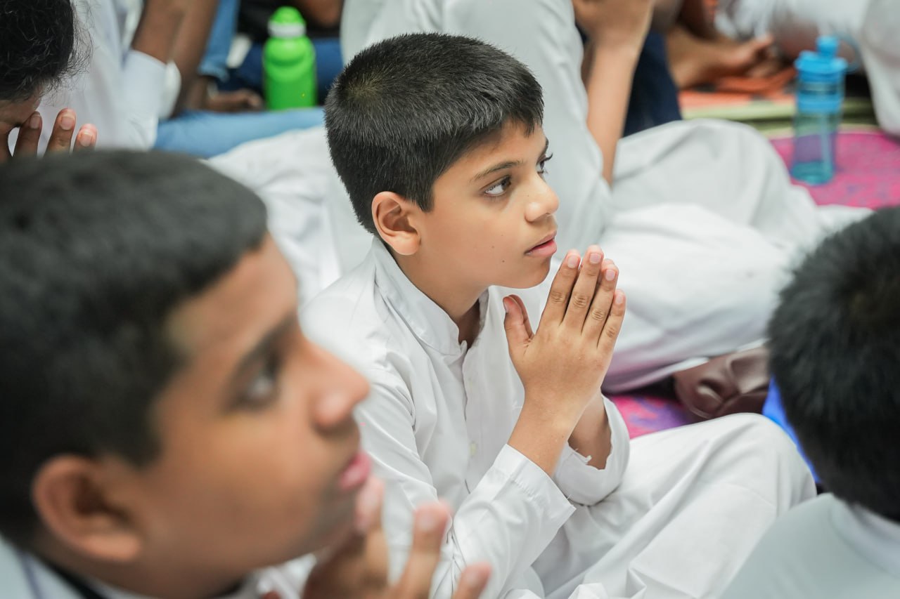 Boy praying in a group of children during a spiritual or educational event.