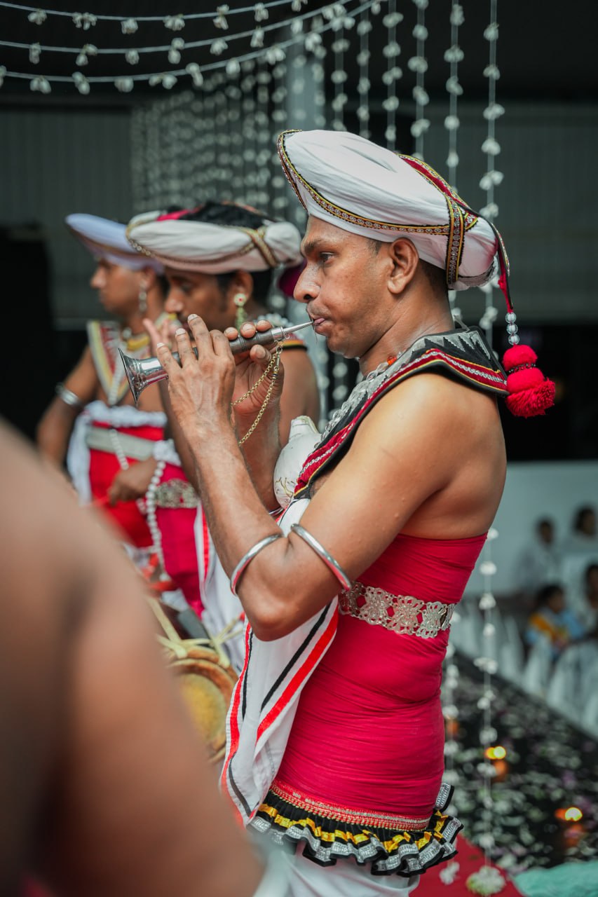 Traditional musicians in vibrant attire performing with wind instruments at cultural event.