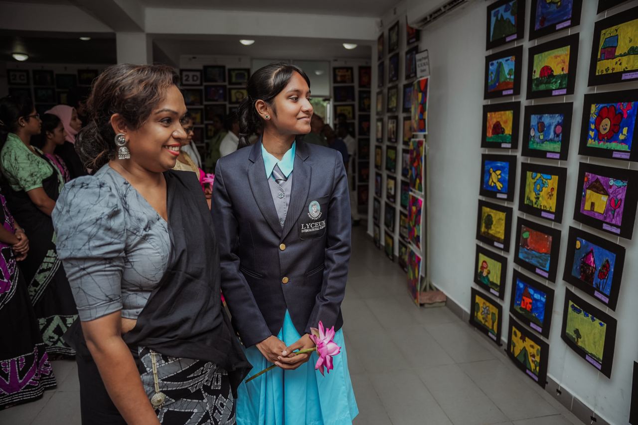 Joyful Moments at the School Art Showcase School art exhibition: girl and woman smiling, vibrant childrens paintings in background.