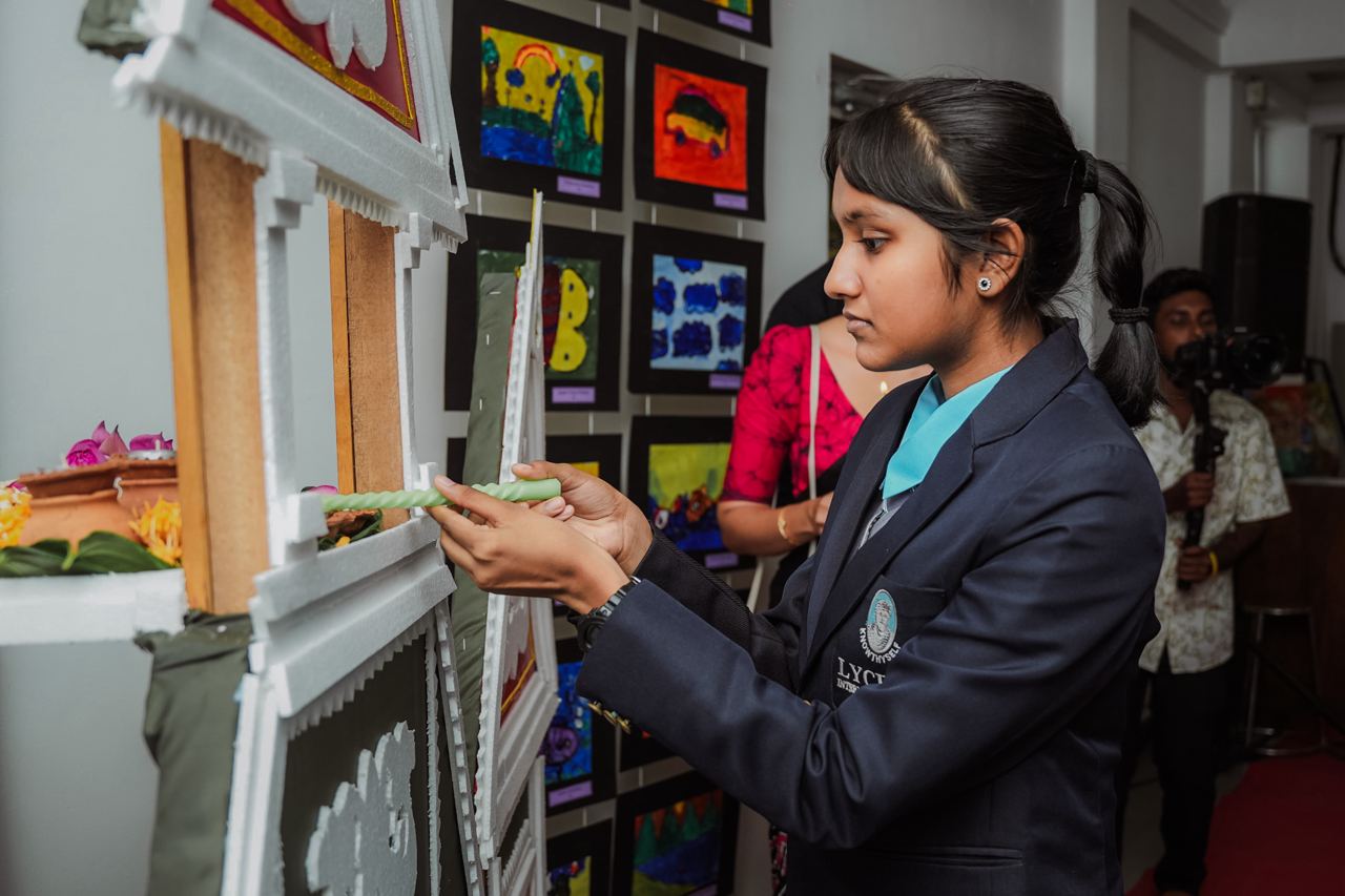 Young Girl Decorates Art Event Display Young girl decorates setup at childrens art event.