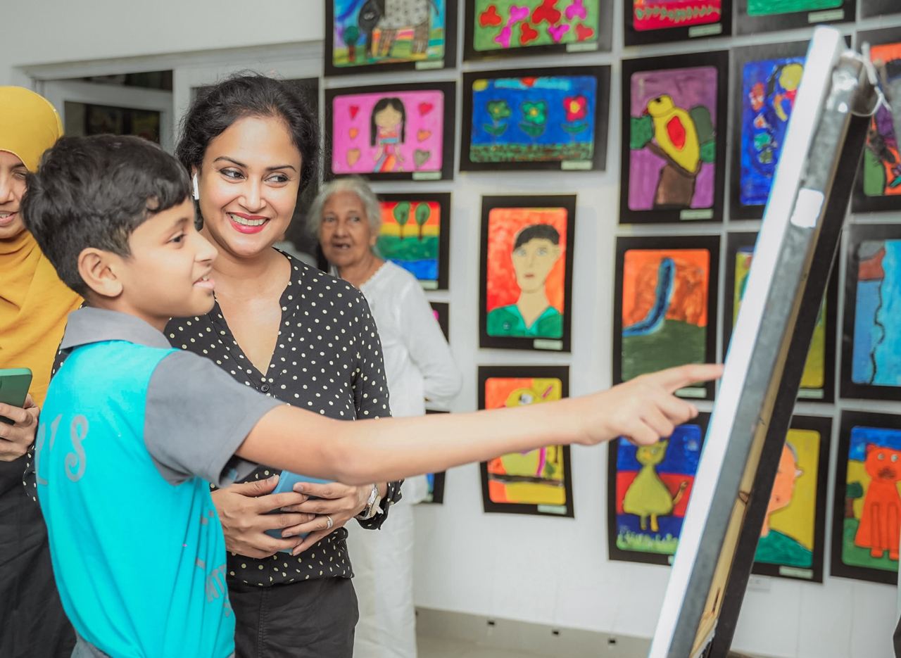 Joyful Moments at the Art Gallery Young boy enthusiastically pointing at art exhibit with smiling woman in gallery.