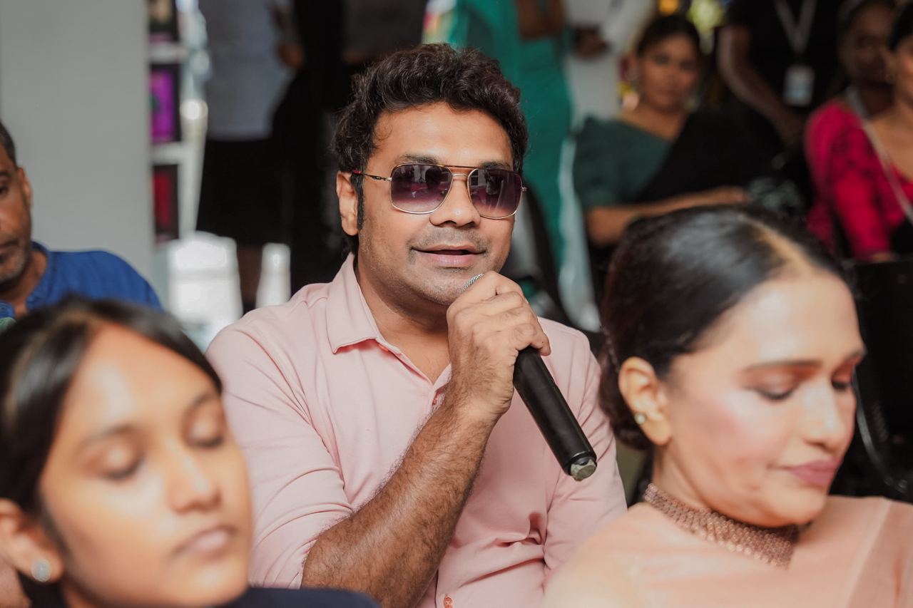 Mr. Peshala Manoj Engages Audience with Microphone Mr. Peshala Manoj speaking into microphone at event.