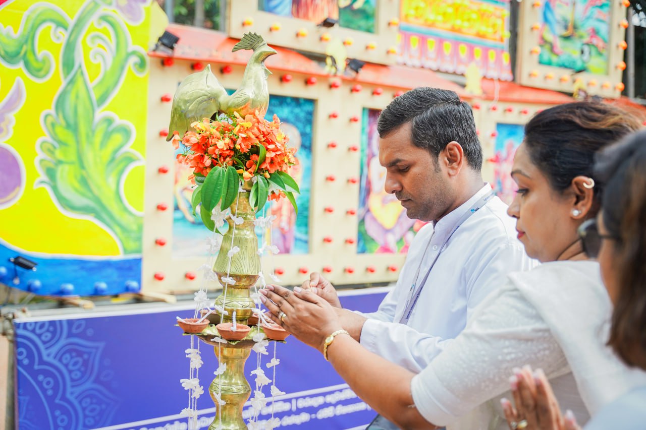 Traditional Indian Ceremony with Ornate Brass Lamp and Flowers Indian ceremony with brass lamp, flowers, clay oil lamps, and participants in white attire.