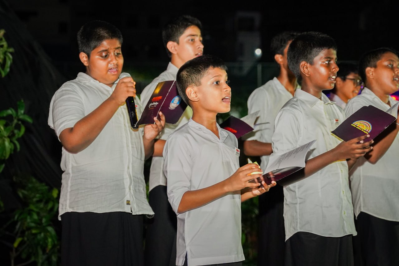 Evening Choir Performance by Boys in Uniform Boys choir in uniform performing outdoors with songbooks and microphone, focused and synchronized.
