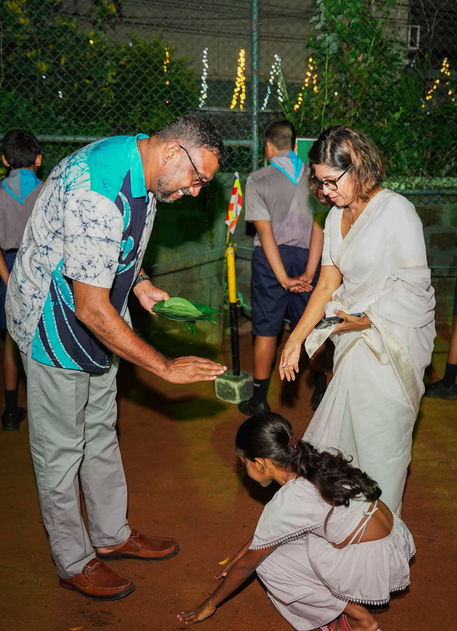 Traditional Night Ceremony: Community Blessing Ritual Outdoor night ceremony with man, woman in sari, and girl performing traditional ritual.
