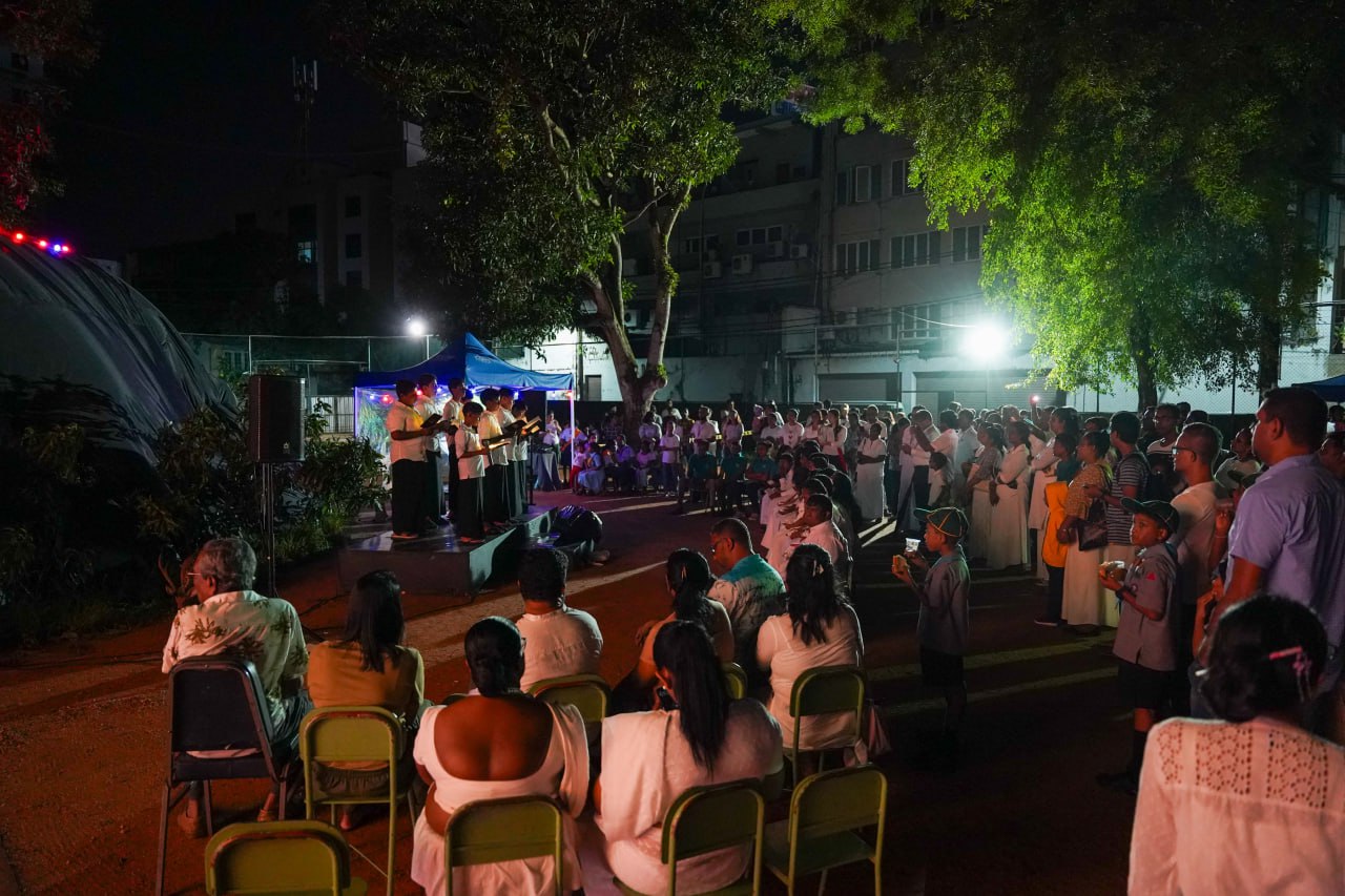 Community Nighttime Choir Performance in Urban Park Nighttime community choir performance in urban park with illuminated trees and captivated audience.