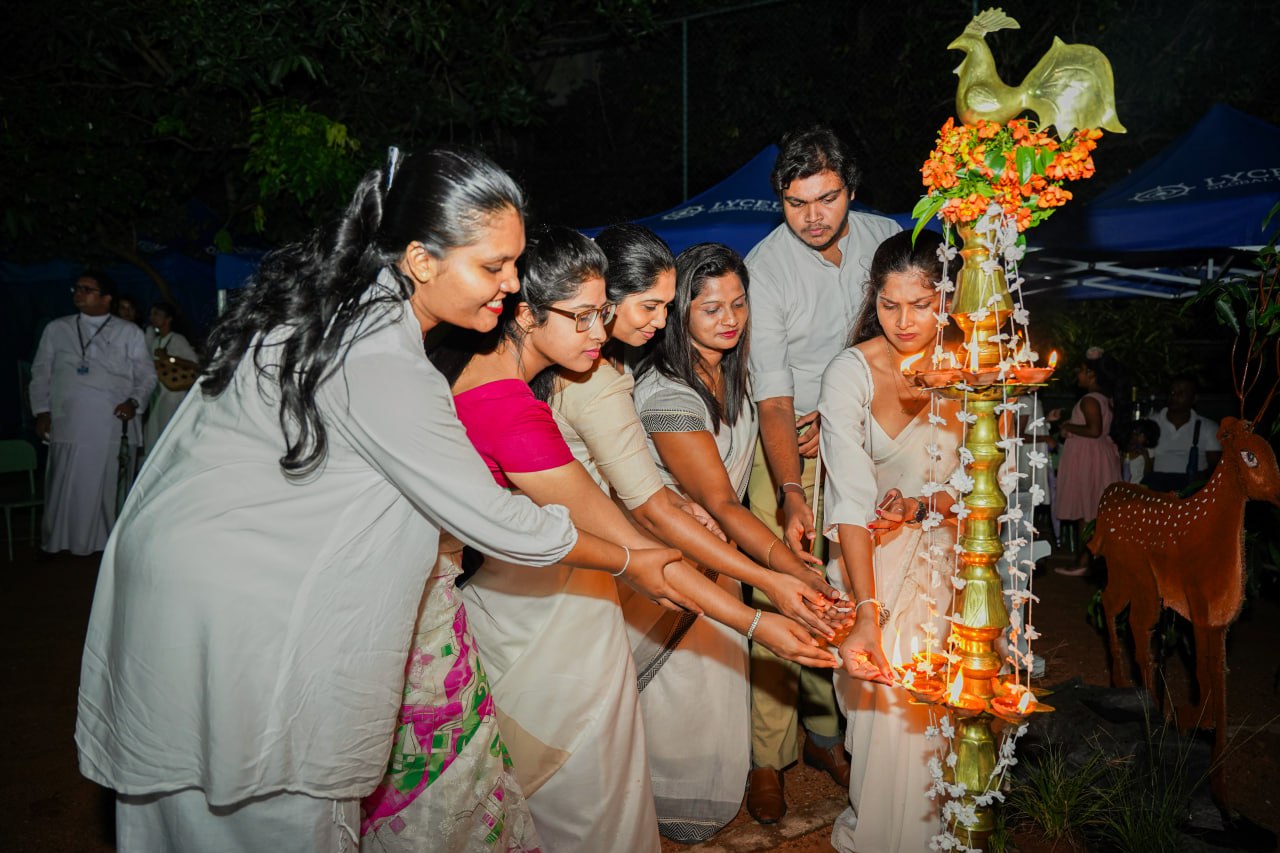 Traditional Lamp-Lighting Ceremony in Elegant Attire Traditional lamp-lighting ceremony with participants in saris and kurta around an ornate brass lamp.