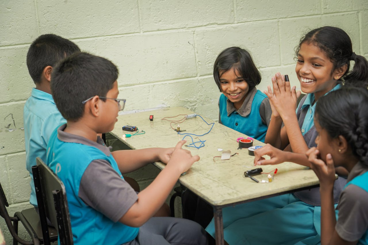 Elementary Students Collaborate on Hands-On STEM Project Elementary students building electrical circuits in a vibrant classroom STEM activity.