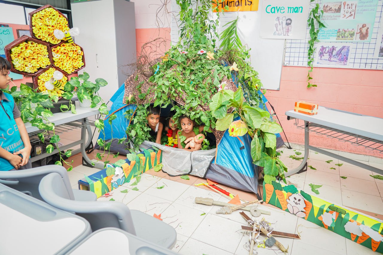 Jungle-Themed Classroom Adventure for Kids Jungle-themed classroom with kids in a tent and nature decorations, fostering creative learning.