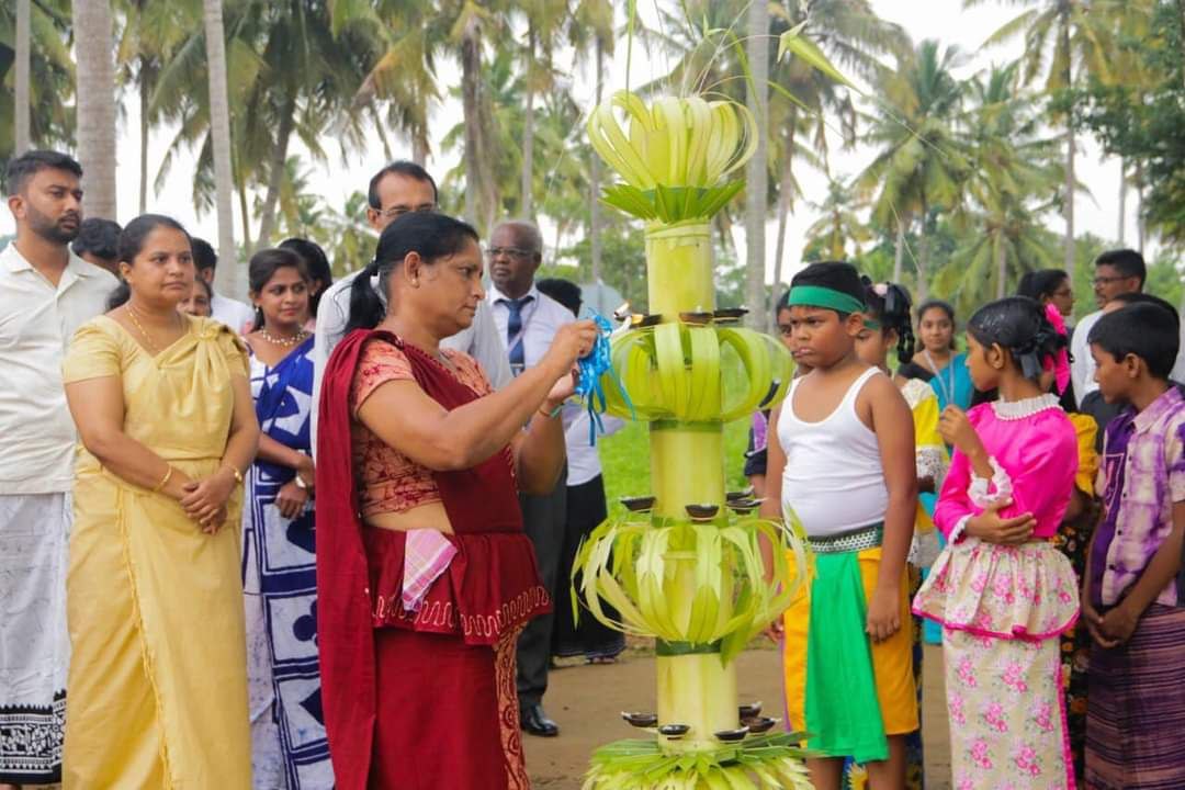 Vibrant cultural ceremony with banana structure, traditional attire, oil lamps, and community participation.