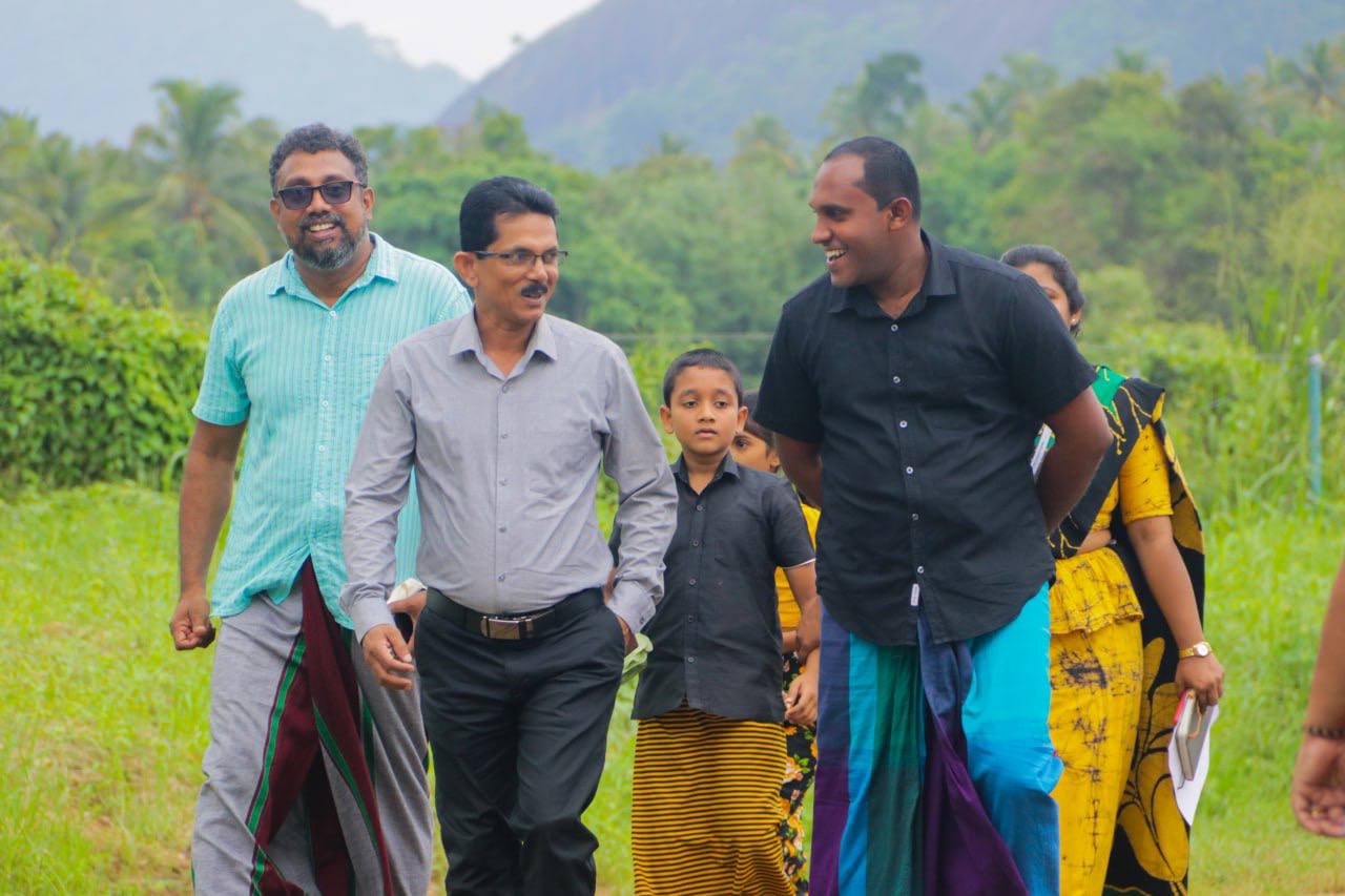 Smiling friends enjoy a nature walk, surrounded by greenery and scenic beauty.