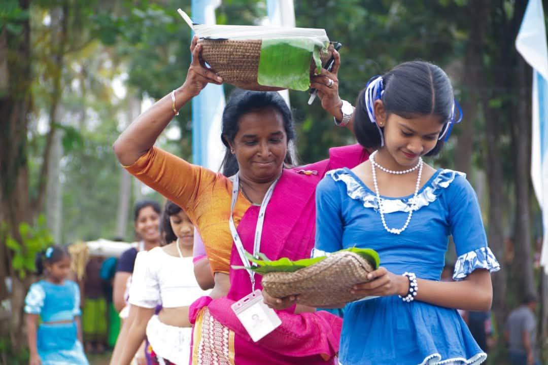 Women in vibrant traditional clothing joyfully participate in an outdoor cultural celebration.