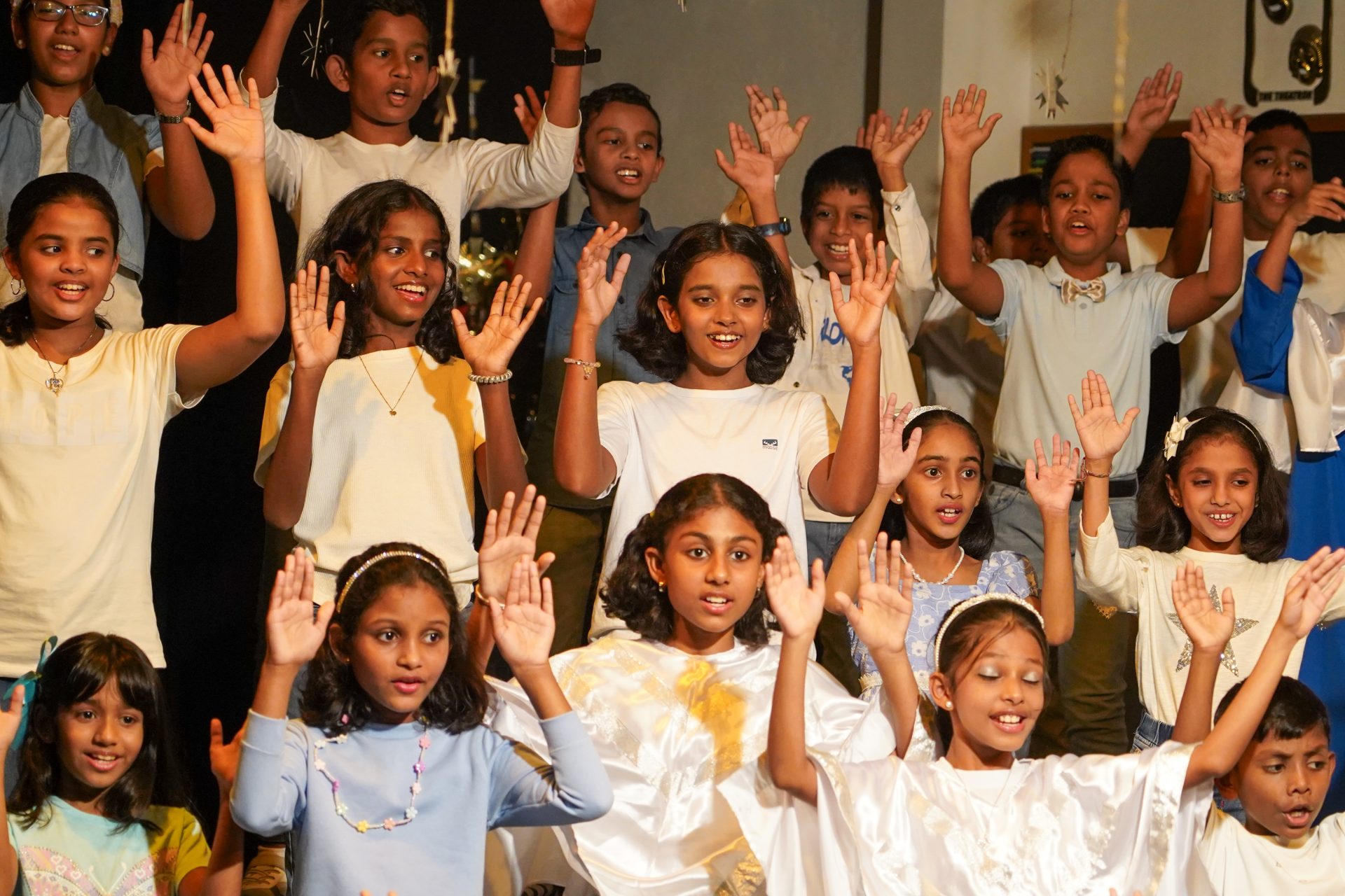 Joyful childrens choir performing in colorful outfits at a festive community event.
