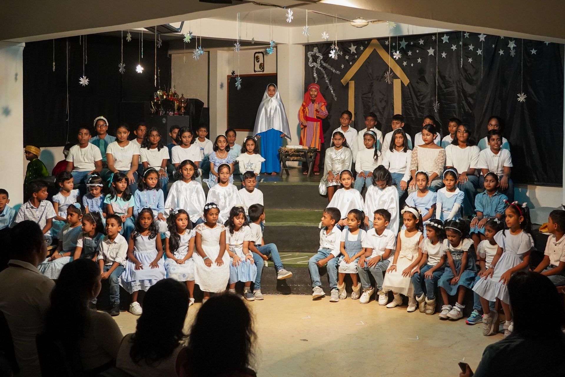 Children perform a charming school nativity play, enchanting audience with traditional costumes and decor.